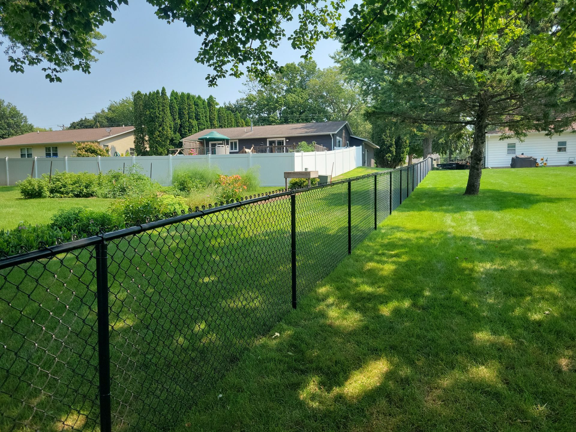 Black Vinyl-Coated Chain Link Fence Installation in New Hampton by Perfect Picket Fence and Stain