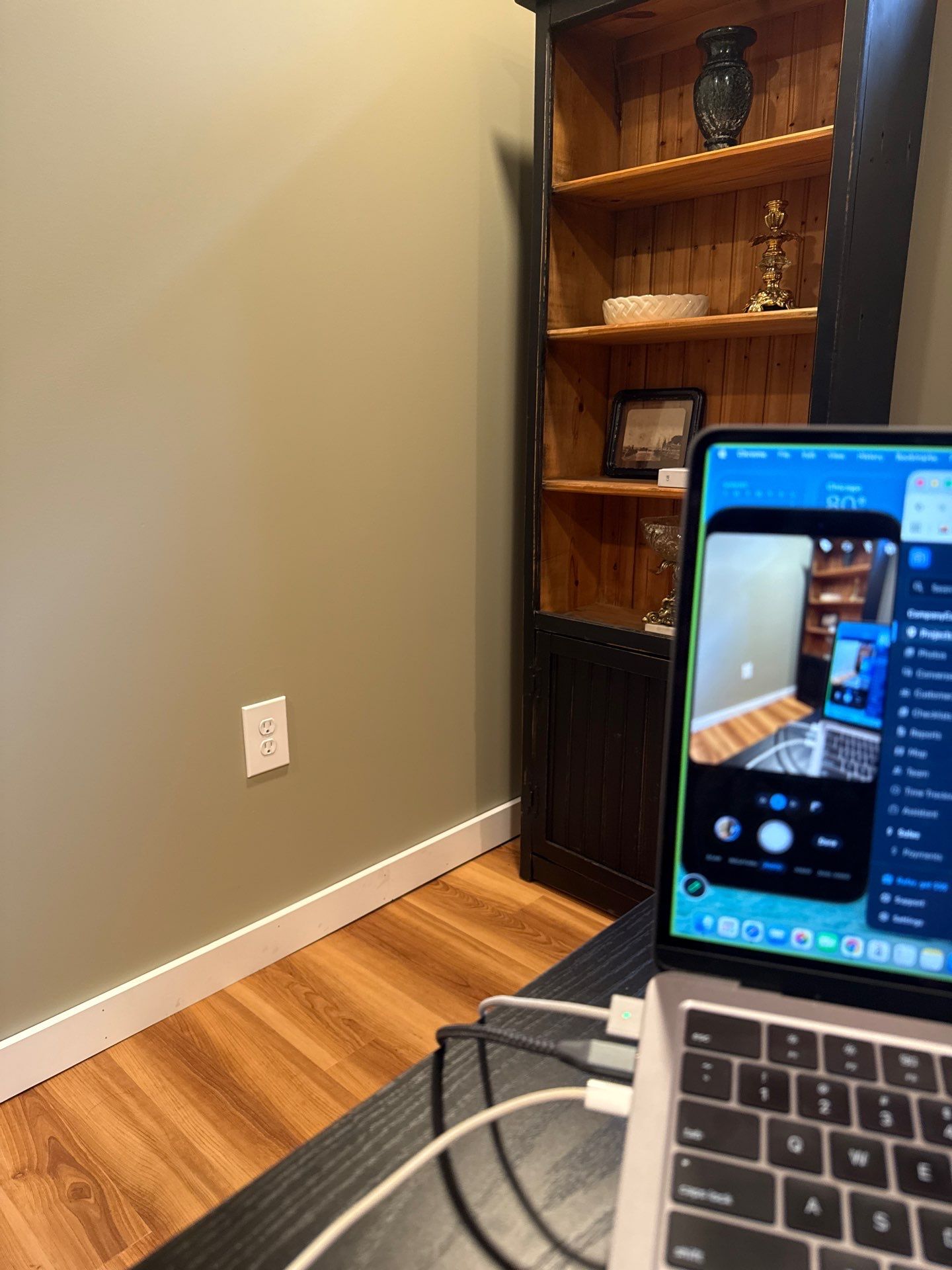 Home Office Setup with Sage Walls and Dark Wood Shelving by CompanyCam Sales Demo