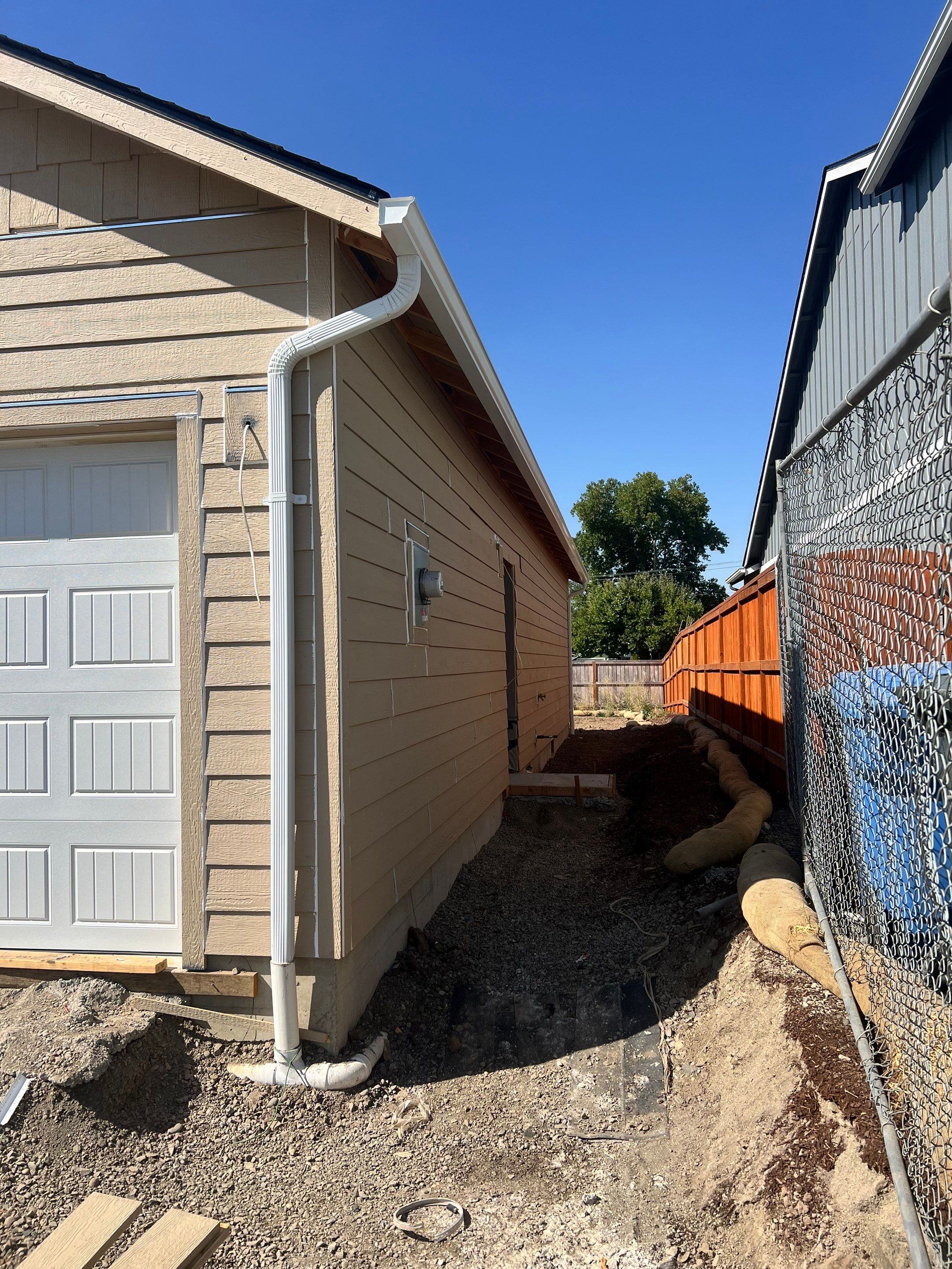 Continuous White Gutter and Downspout Installation for New Eugene Home by BEST Roofing & Waterproofing