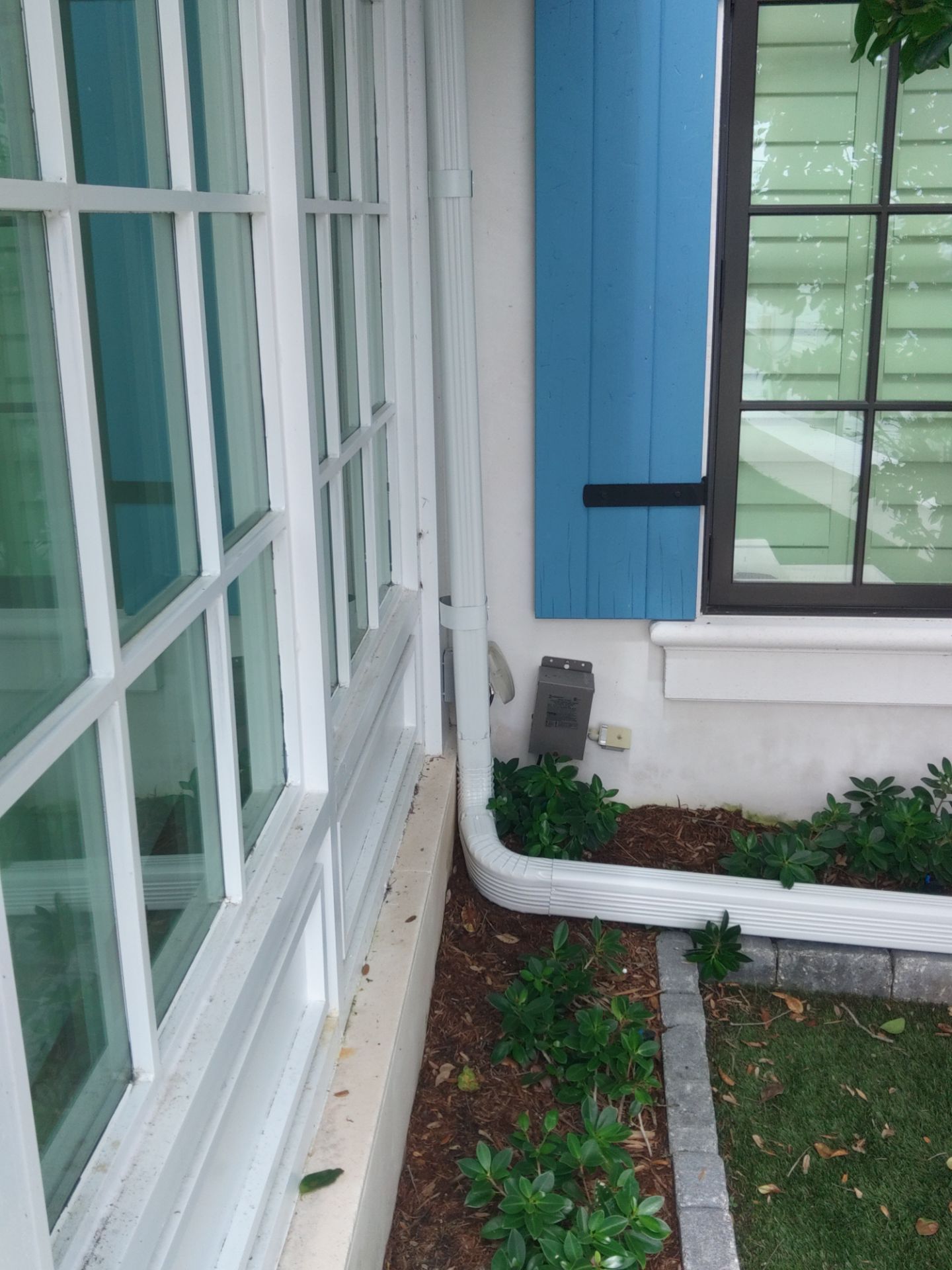 Seamless aluminum gutter installation in Sarasota, FL using 3x4 elbow downspouts combined with round downspouts by Gutter Professors