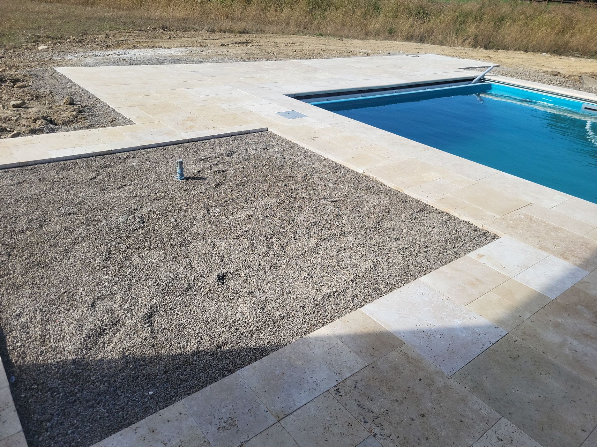 Custom Travertine Pool Deck with Artificial Turf Insets in Delaware by Southwest Greens Midwest