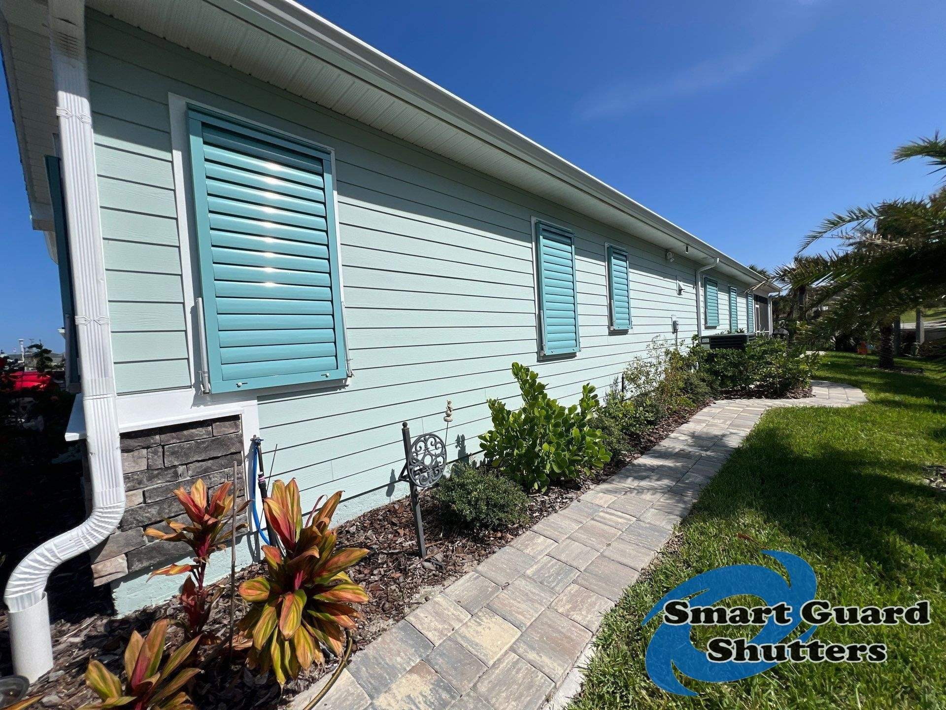 Impact Bahama Shutters in Pastel Turquoise by Smart Guard Shutters