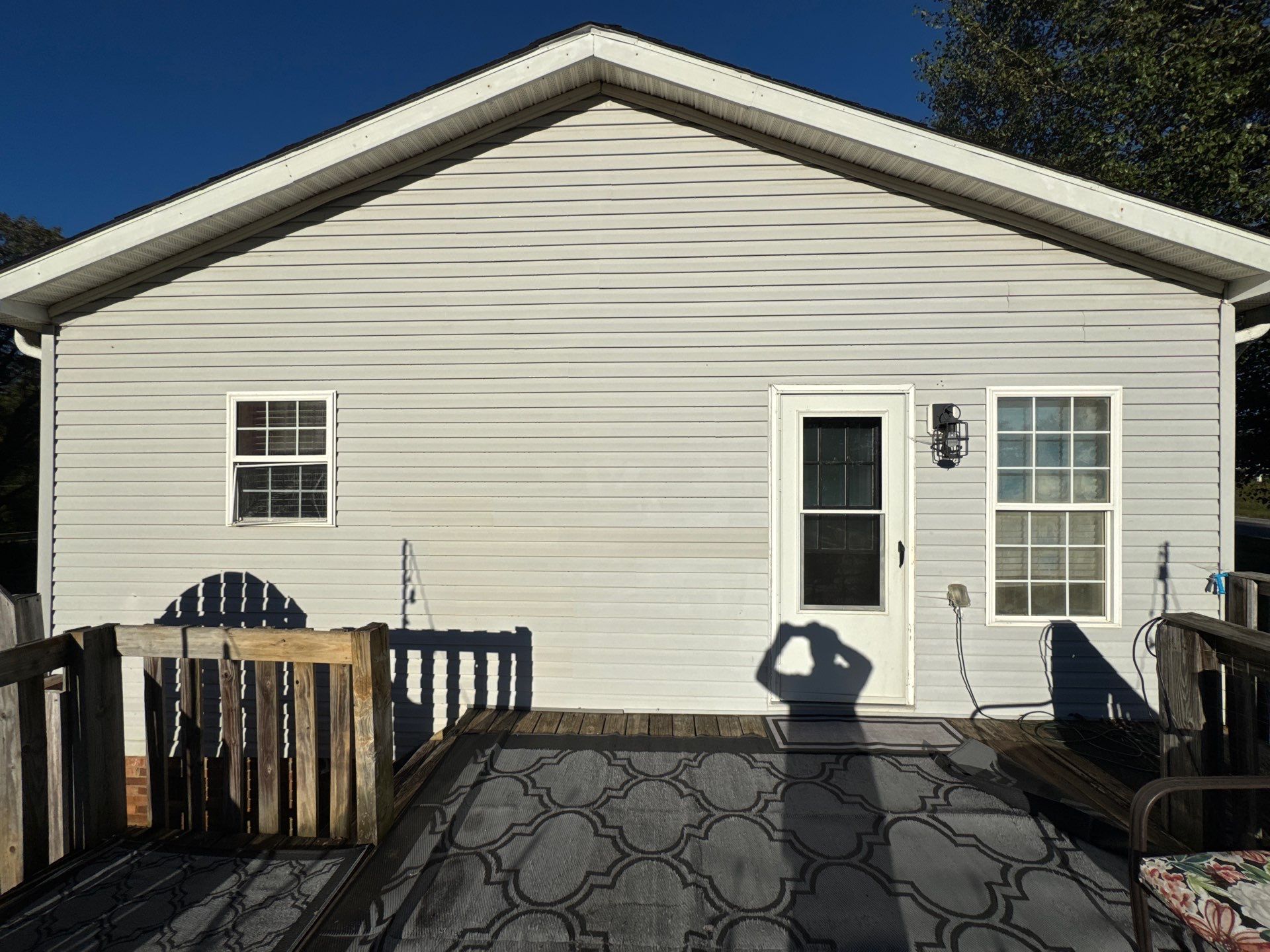 the service is cleaning the exterior siding and decking using pressure washing techniques to remove dirt and grime