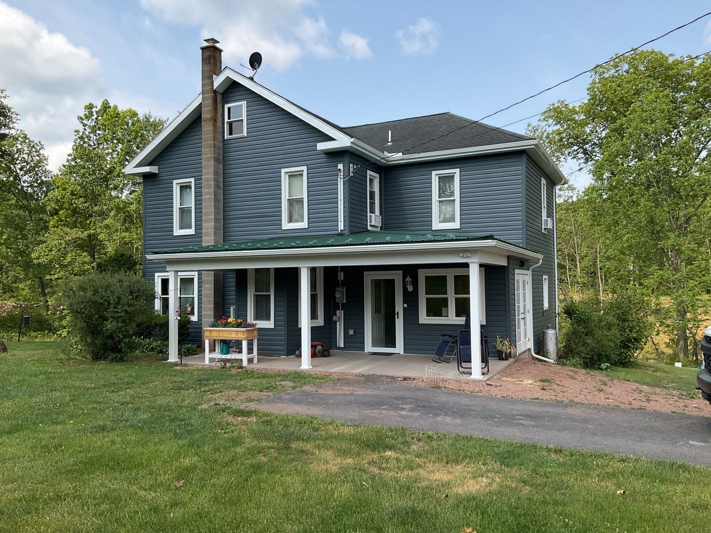 Porch roof [green] and new siding by Esh Builders