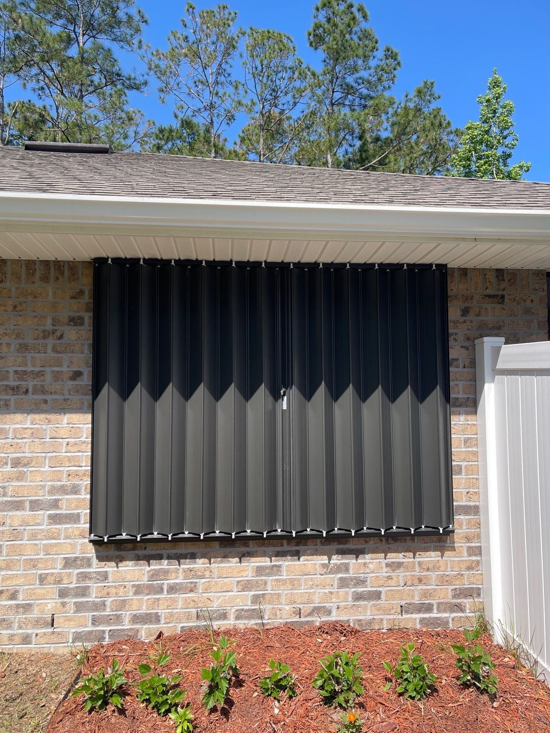 Bronze Accordions on brick home by Smart Guard Shutters