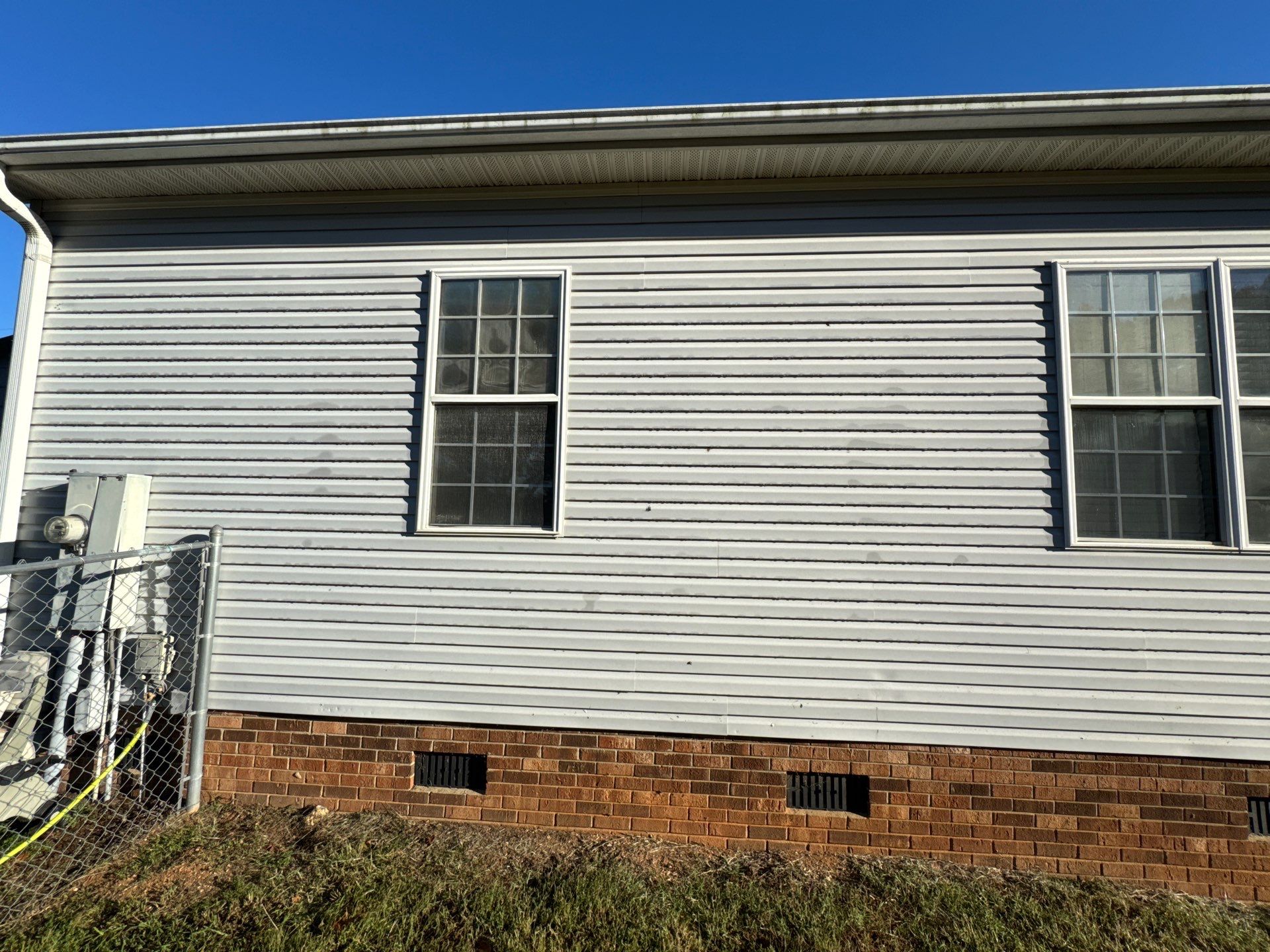 the service being done is cleaning the exterior siding and brick of a house to remove dirt and stains