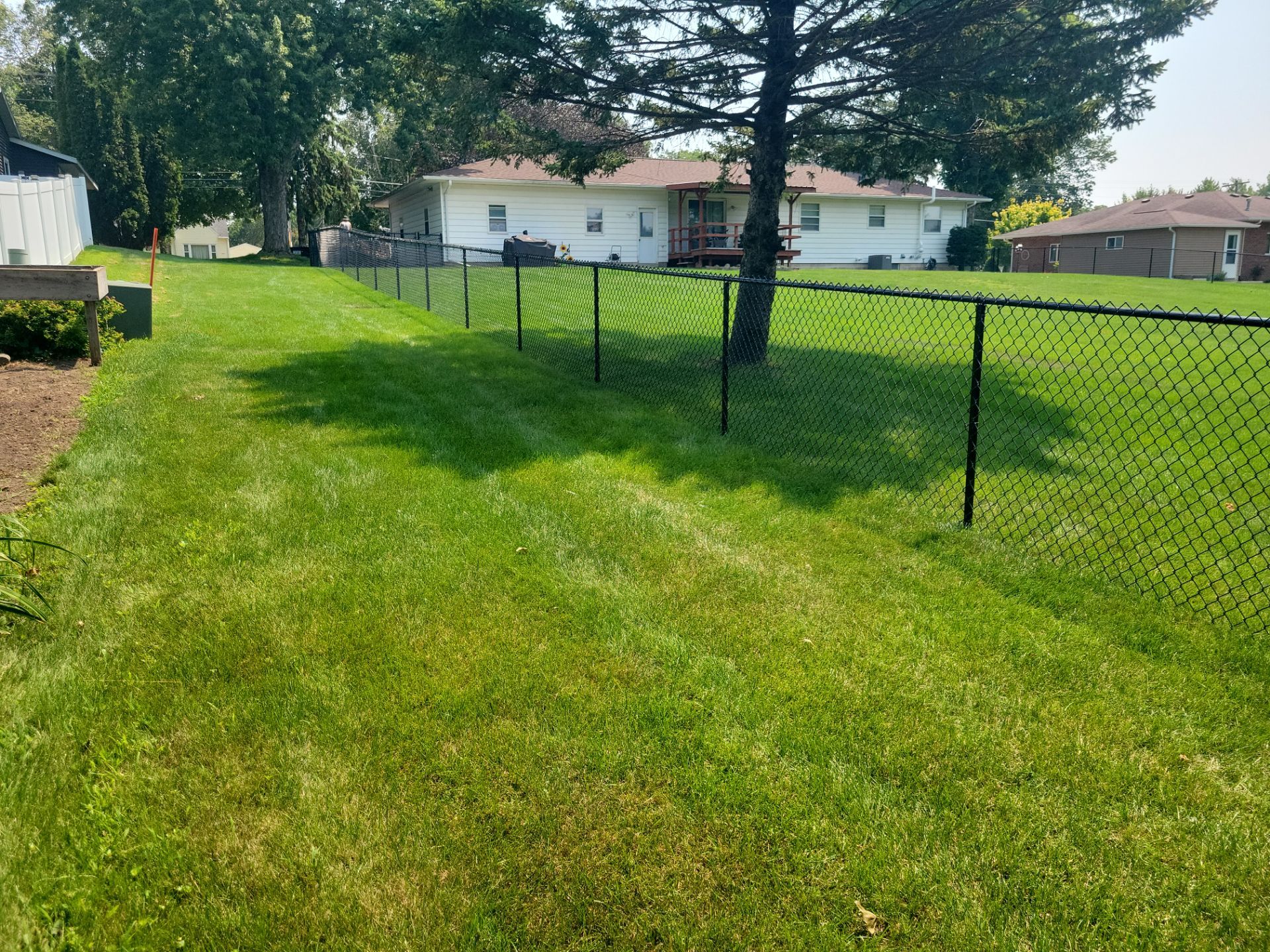 Black Vinyl-Coated Chain Link Fence Installation in New Hampton by Perfect Picket Fence and Stain