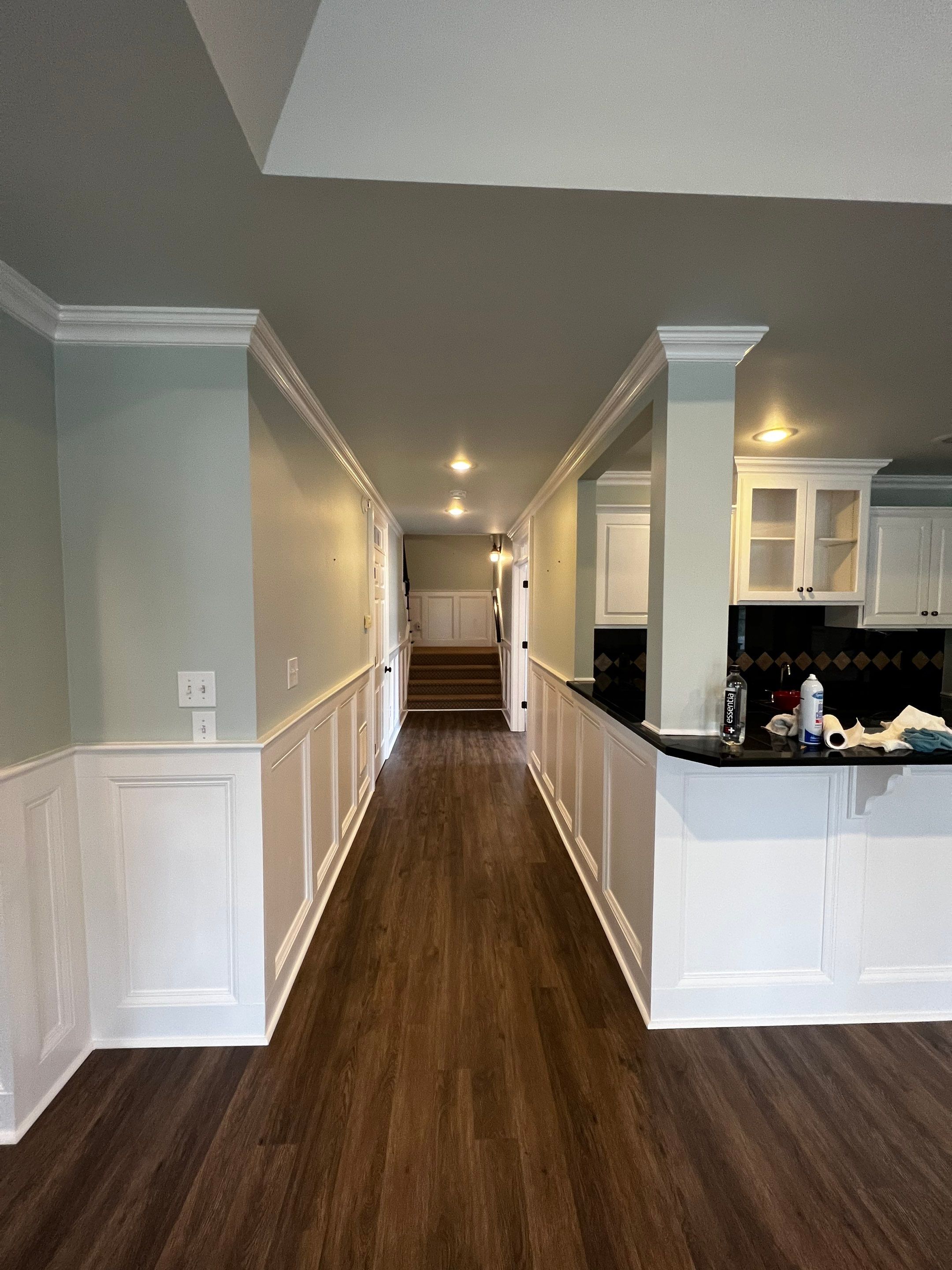 Finished Basement Remodeling with Dark Wood-Look Flooring and Custom Wainscoting by Swift Home Renovations 