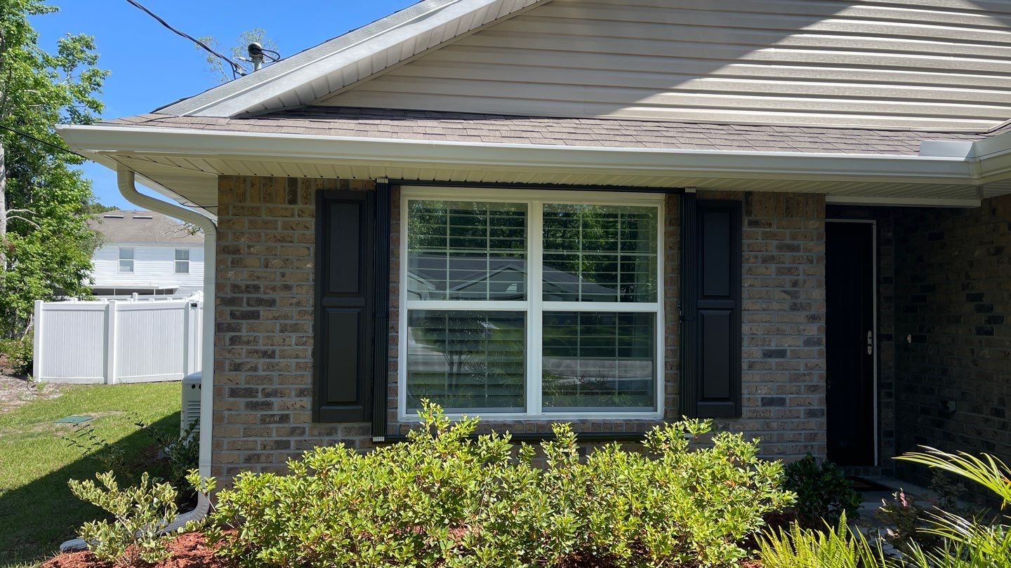 Bronze Accordions on brick home by Smart Guard Shutters
