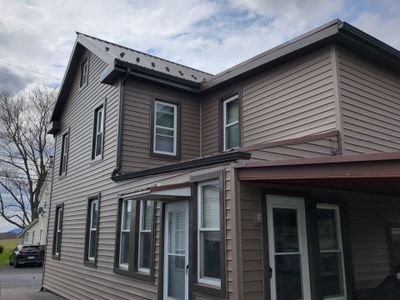 Exterior Renovation with Vinyl Siding, Metal Roof & Spouting