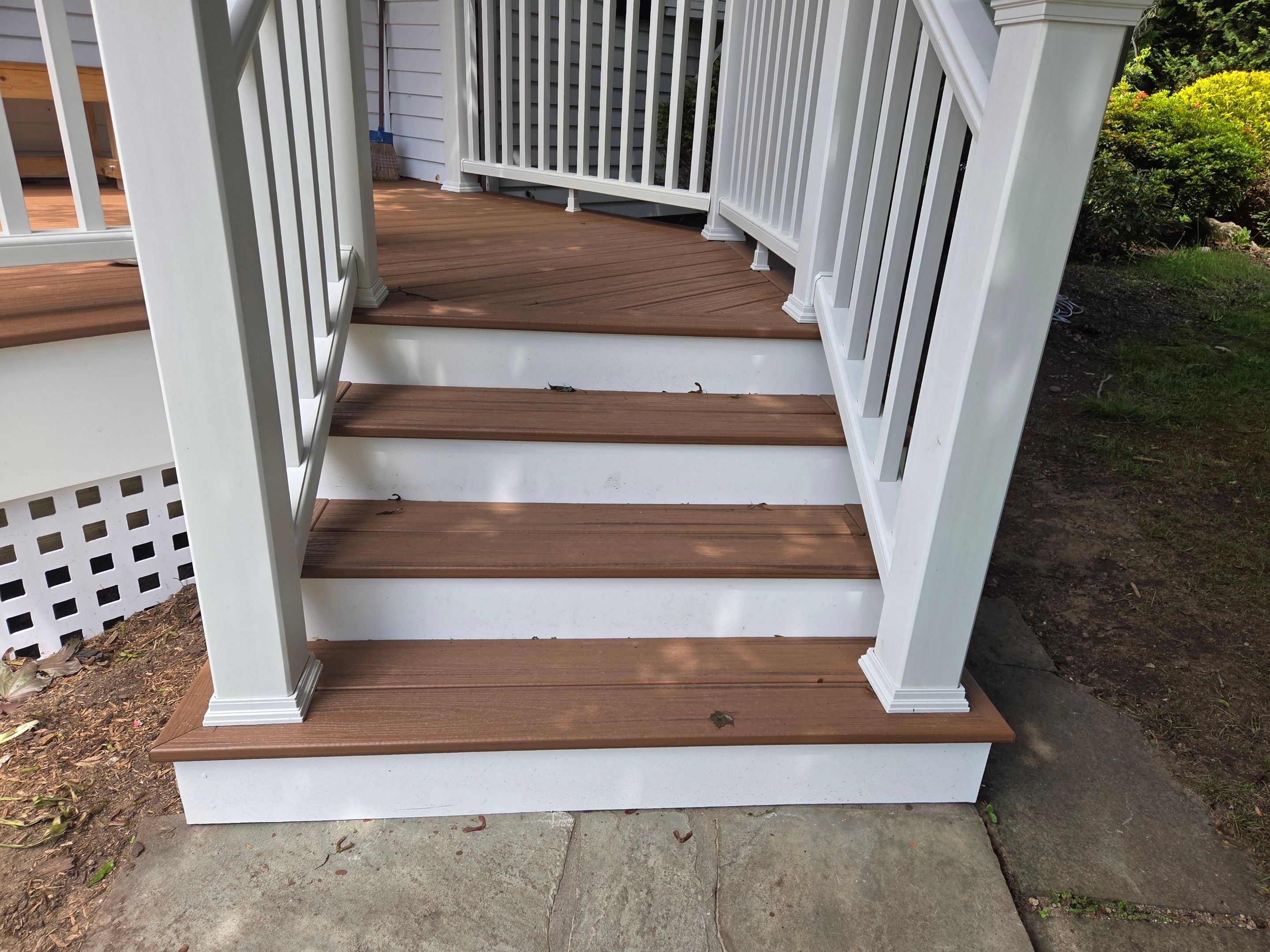 Deck Replacement, Trex Tiki torch boards, with White composite railing and lattice. by DiGiorgi Roofing and Siding Inc