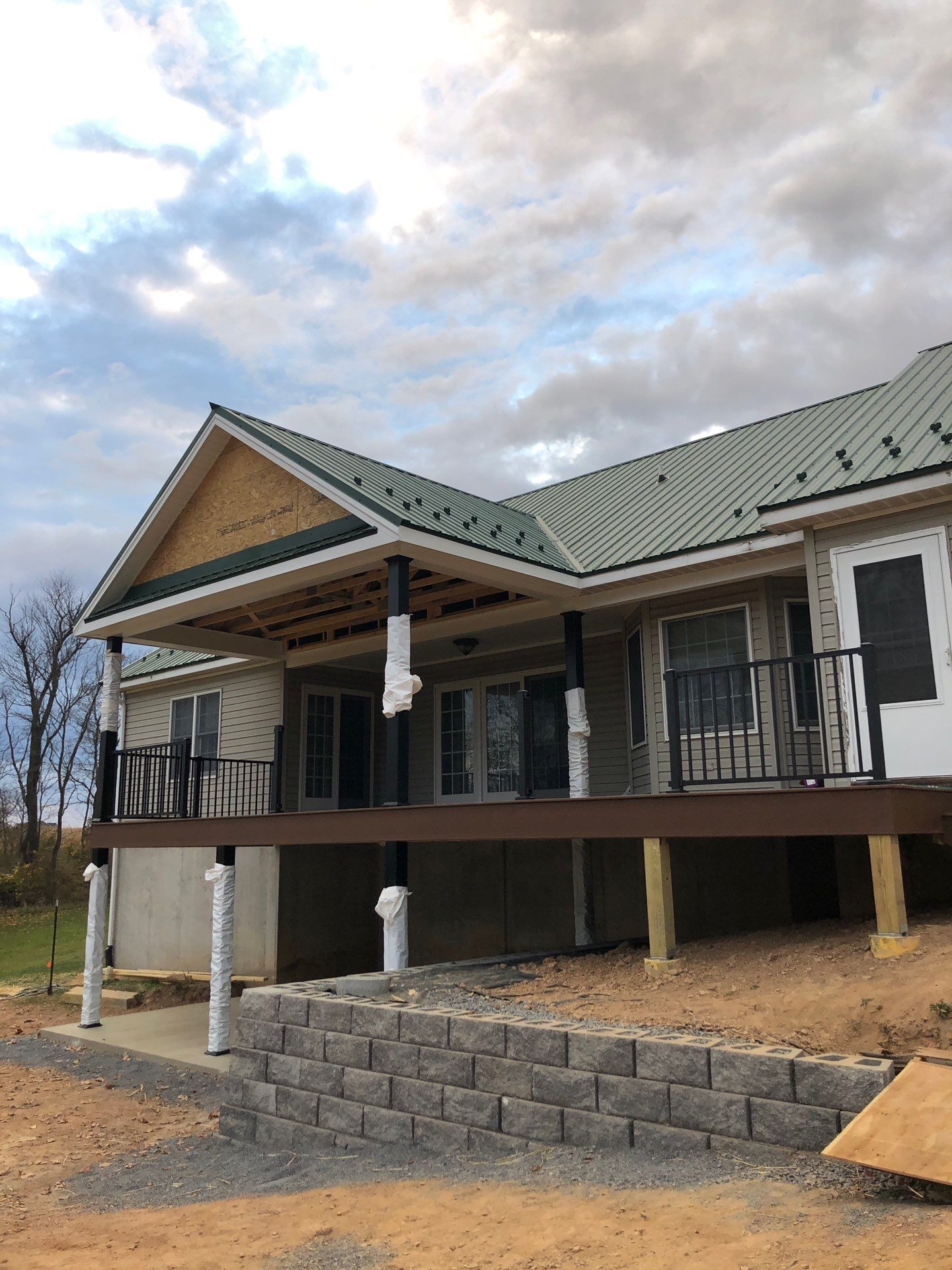 Green Metal Roof and Custom Covered Deck in Duncannon by Esh Builders