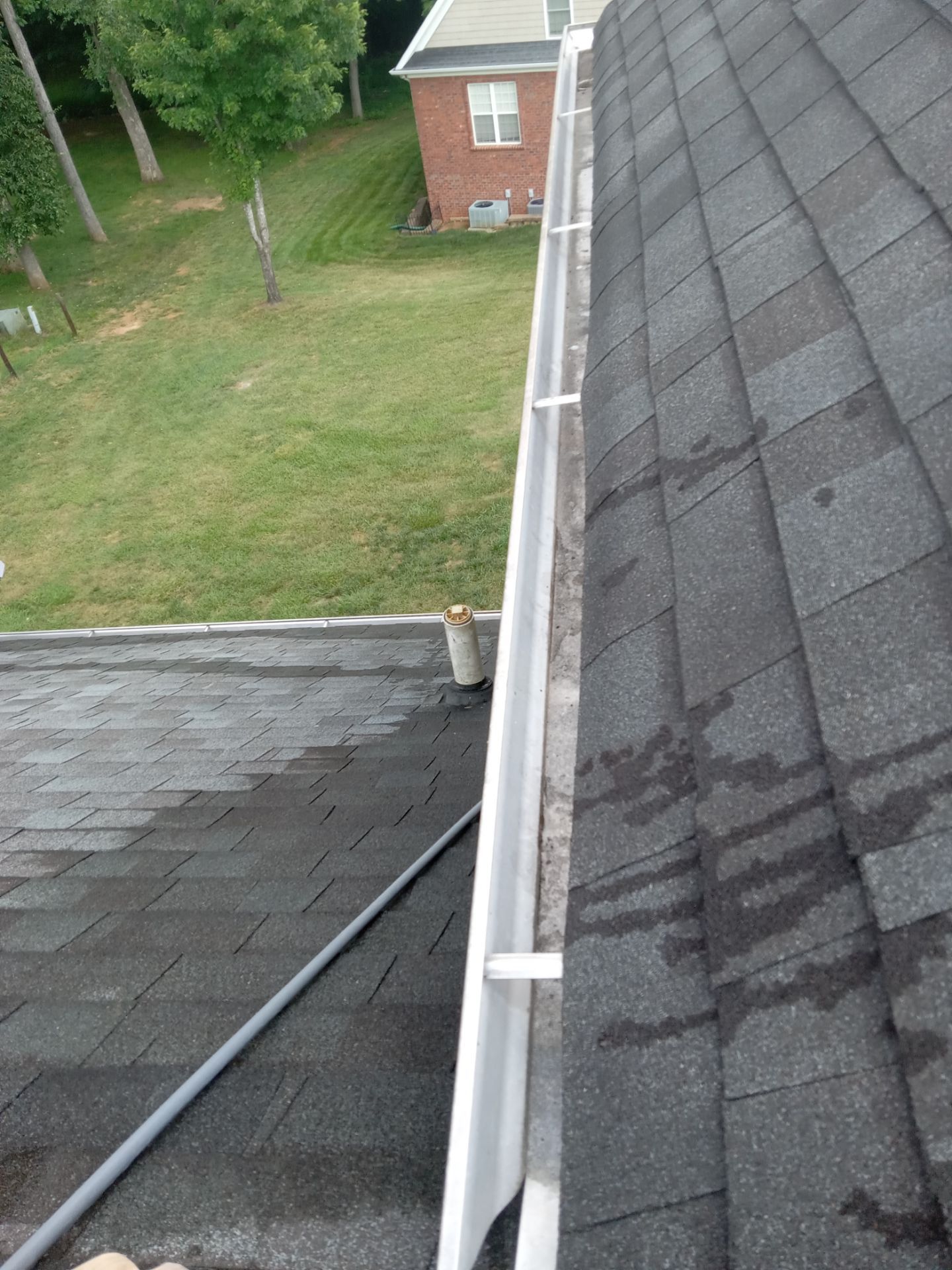 cleaning house gutters and roof removing debris mold and dirt buildup with high pressure water washing