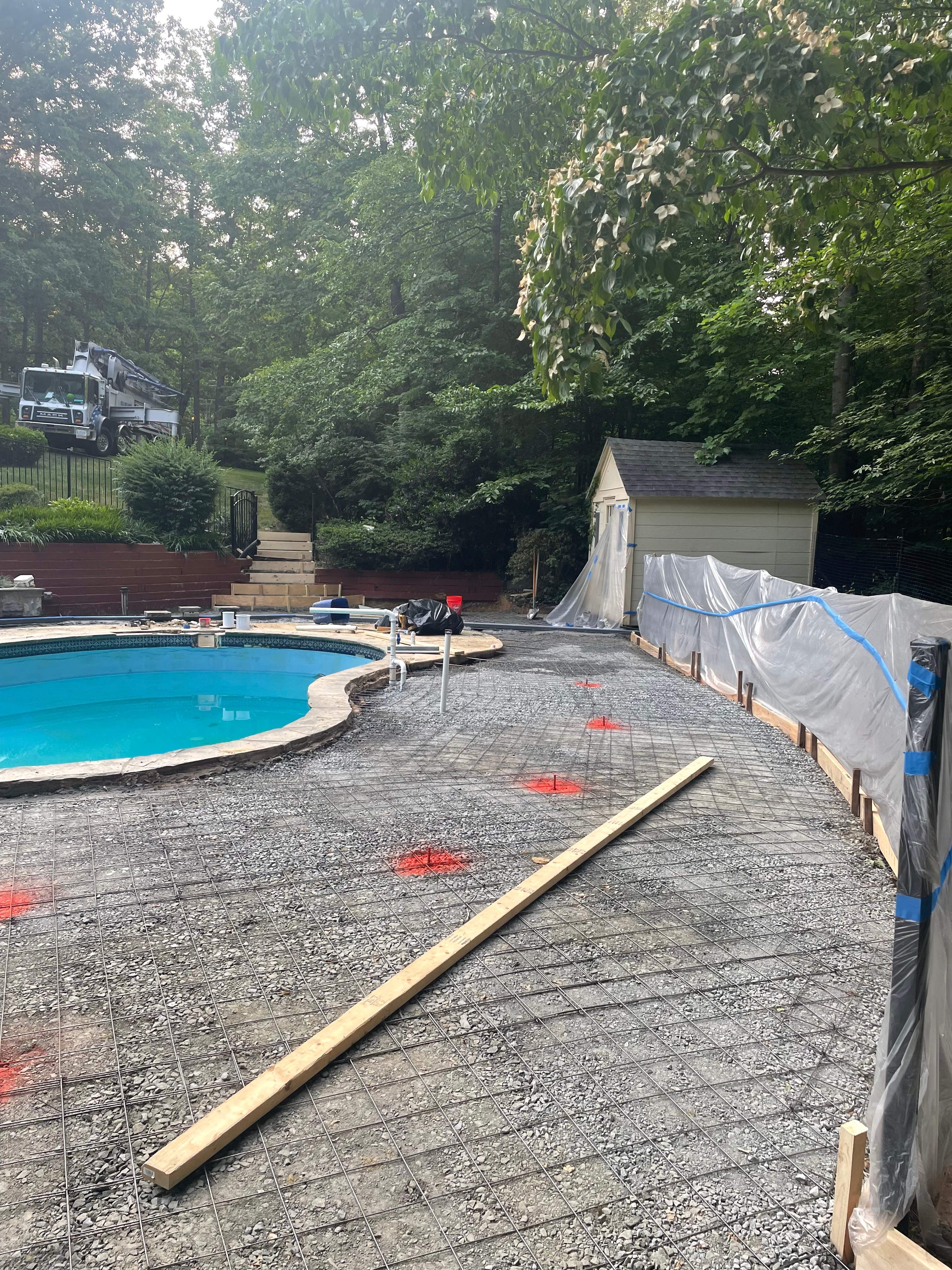 Pool Surround remodel with retaining walls, new waterfall and water slide by Fairfax Contractors, LLC