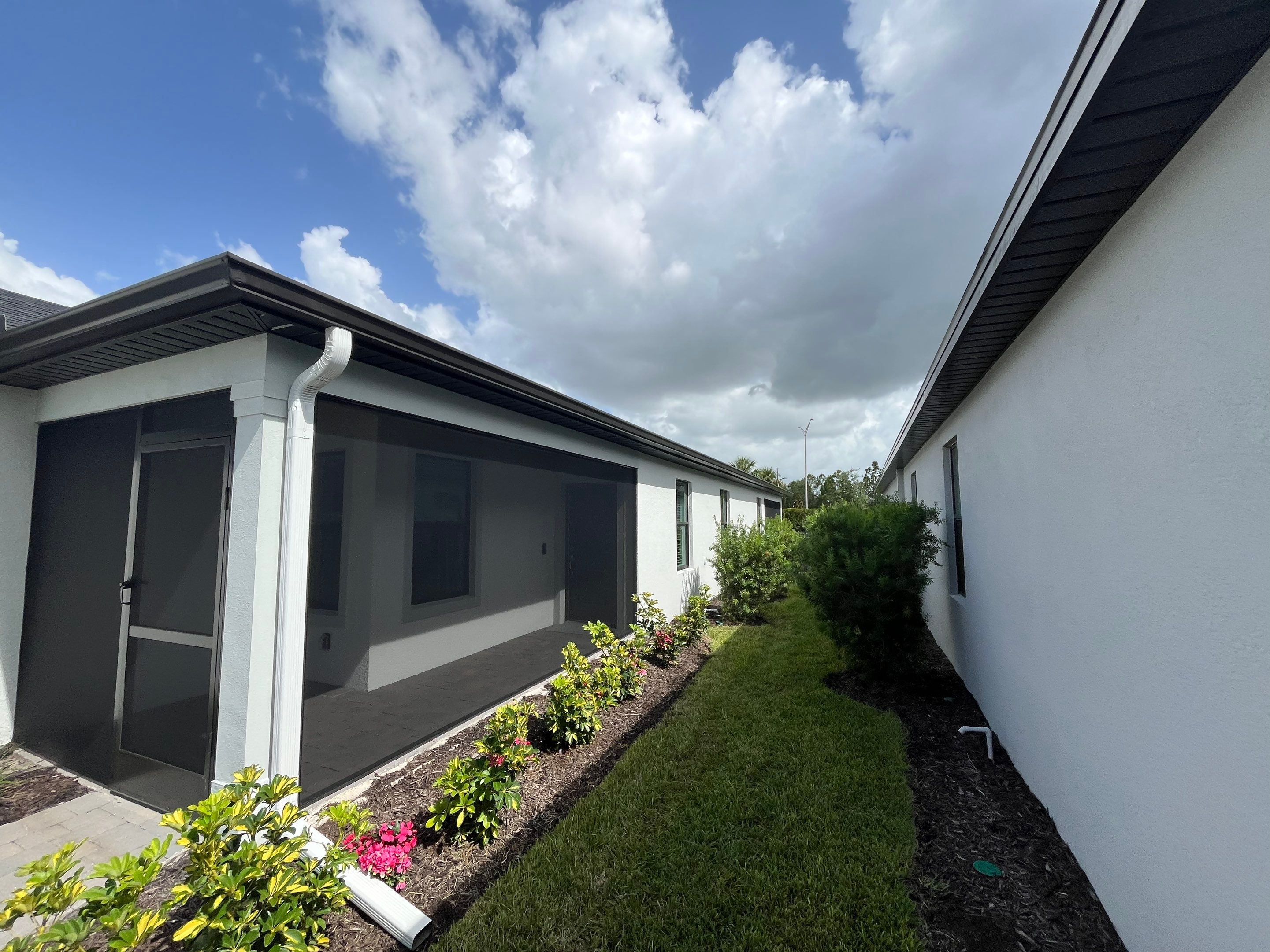 Dark Bronze Gutters and White Downspouts in Sarasota FL by Gutter Professors