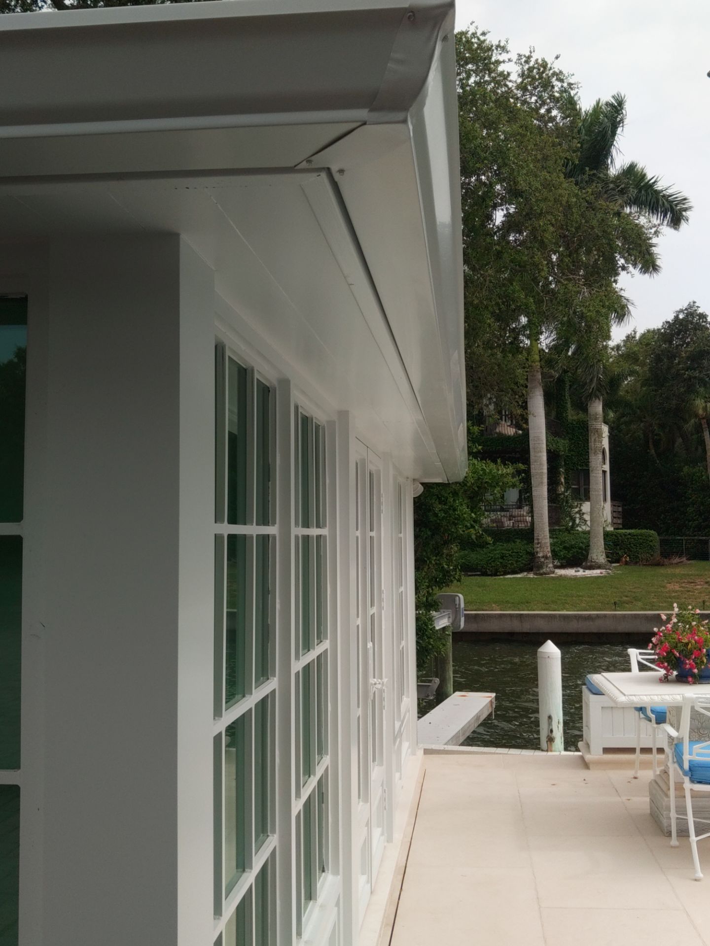 Seamless aluminum gutter installation in Sarasota, FL using 3x4 elbow downspouts combined with round downspouts by Gutter Professors