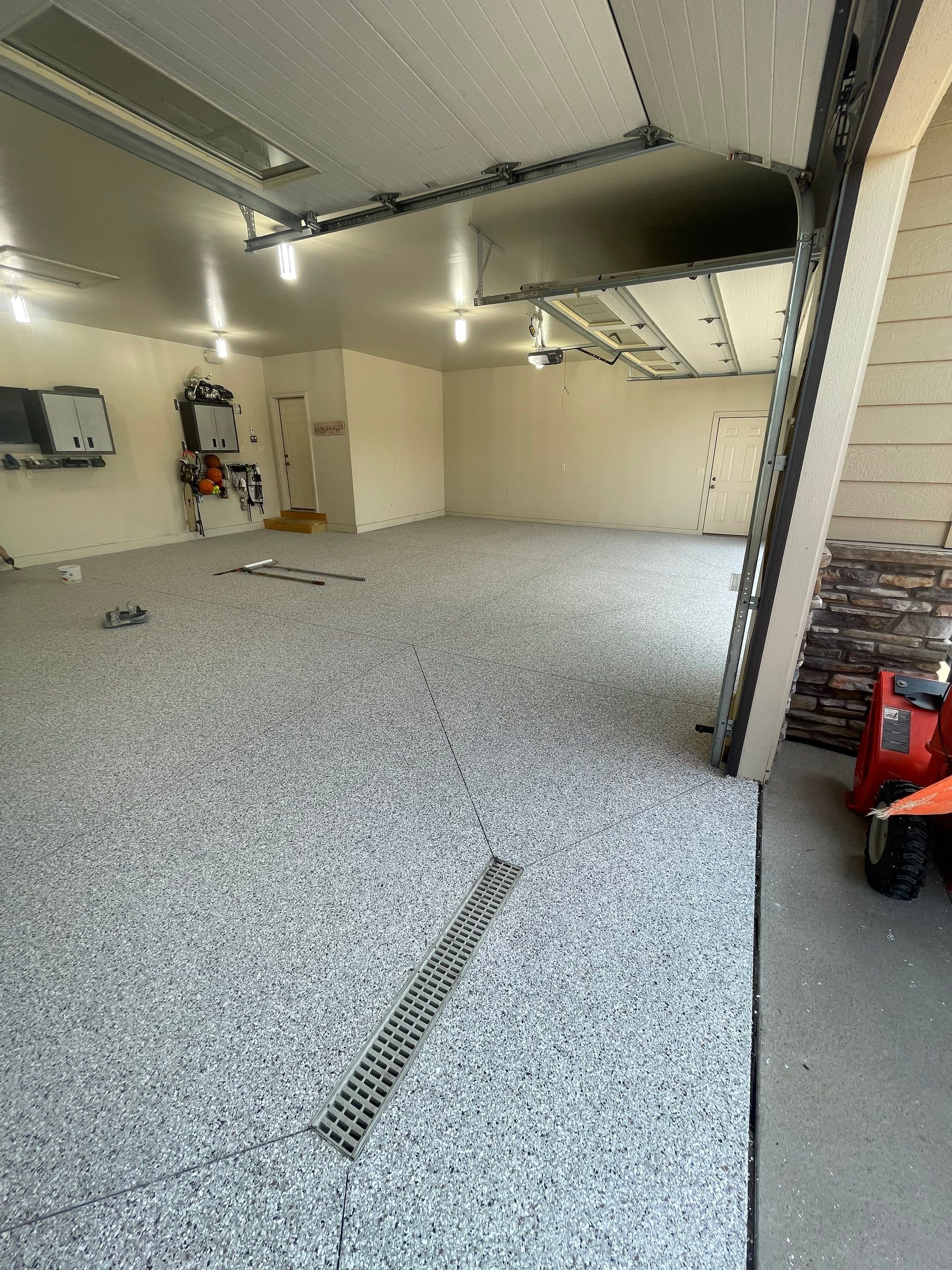 Coyote Flake Garage Floor Coating in Sioux Falls with Trench Drain by Select Painting, Coatings & Garage Cabinets