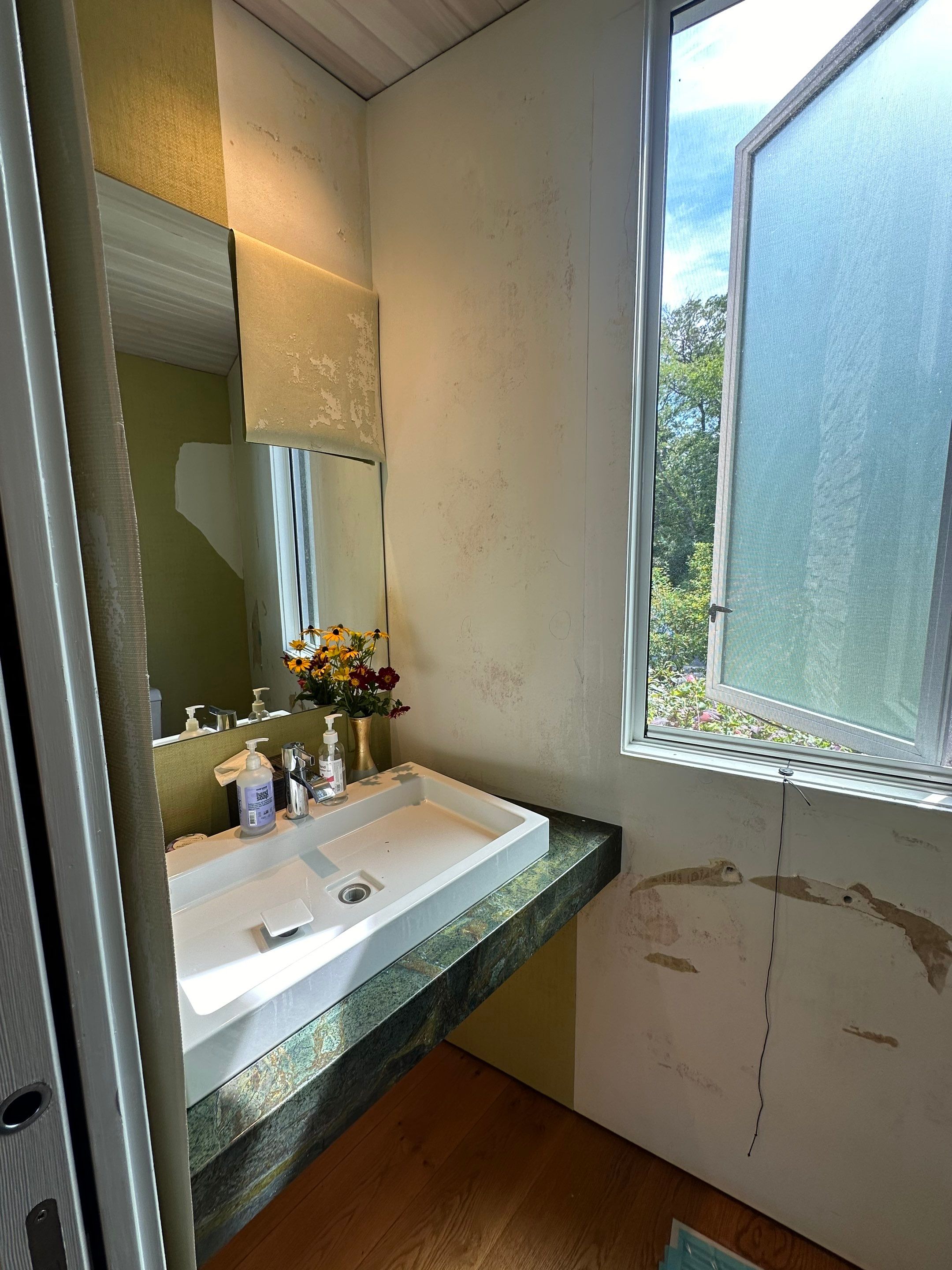 Water saturated exterior wall in half bathroom by BlueRed Restoration