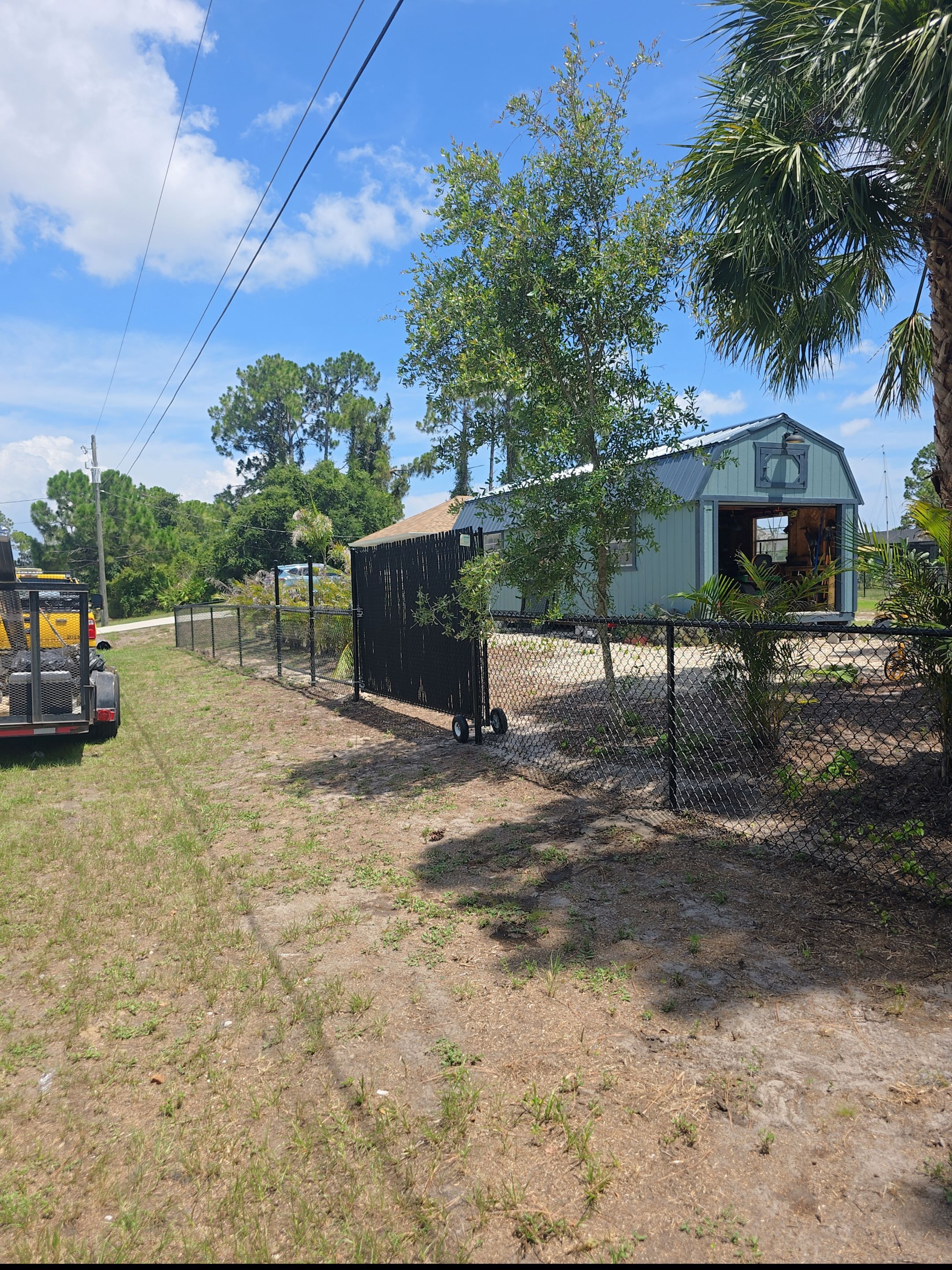 Black Vinyl-Coated Chain Link Fence and Rolling Gate Installation in North Port by True Fence LLC