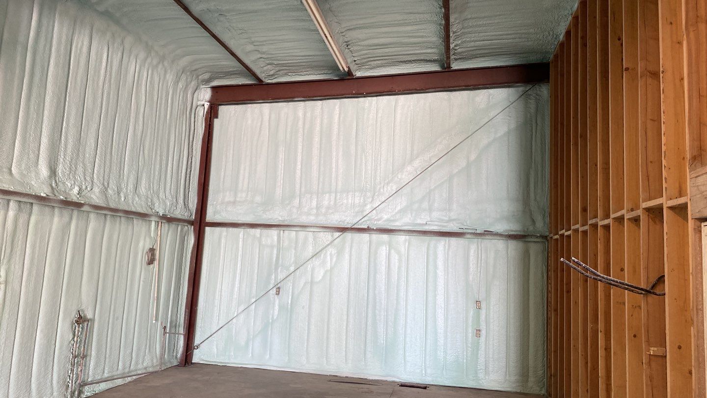 Spray foam insulation on inside of metal industrial building by Straight Edge Roofing Inc