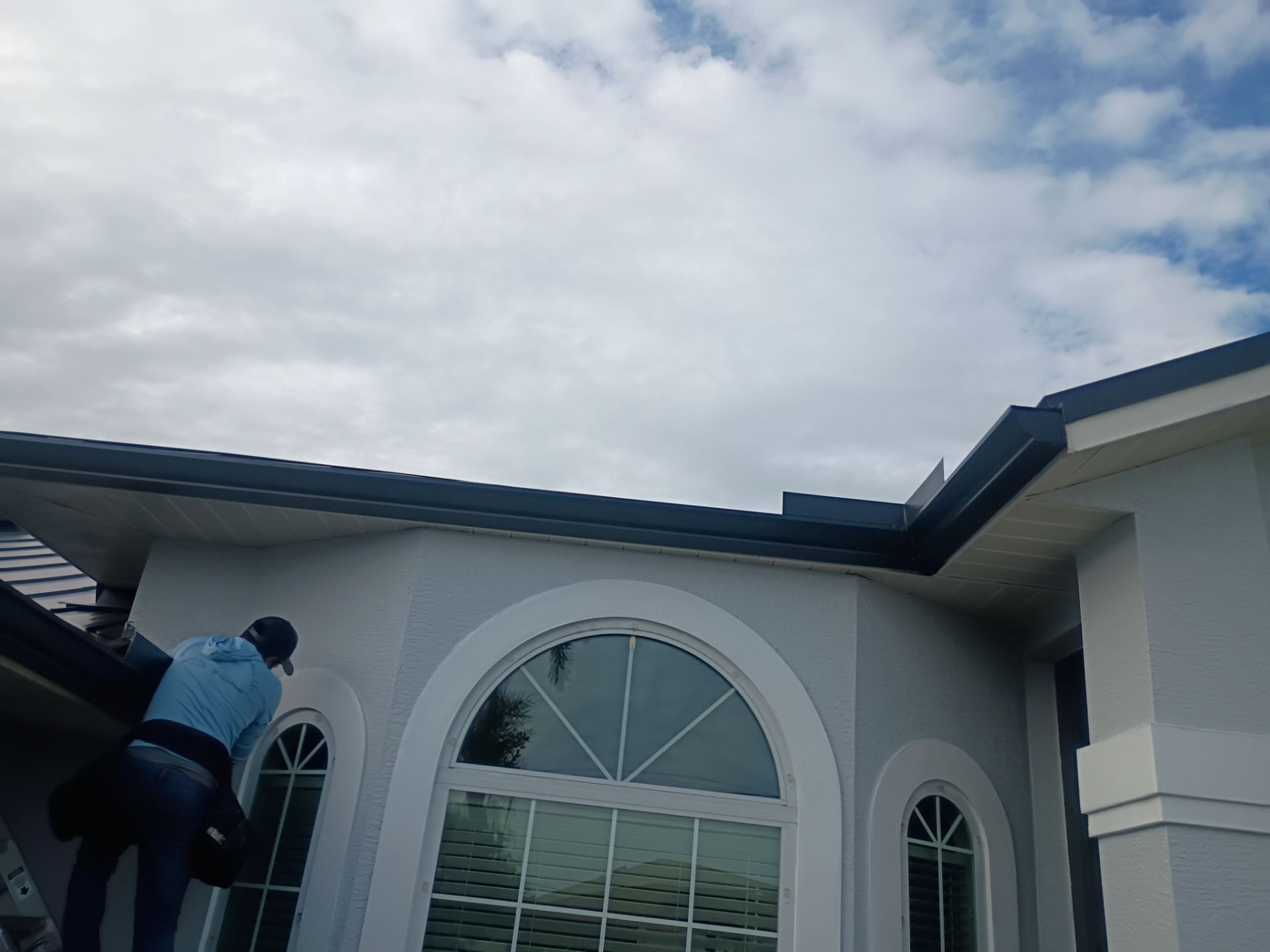Black Seamless Gutters and White Downspouts in Cape Coral FL by Gutter Professors