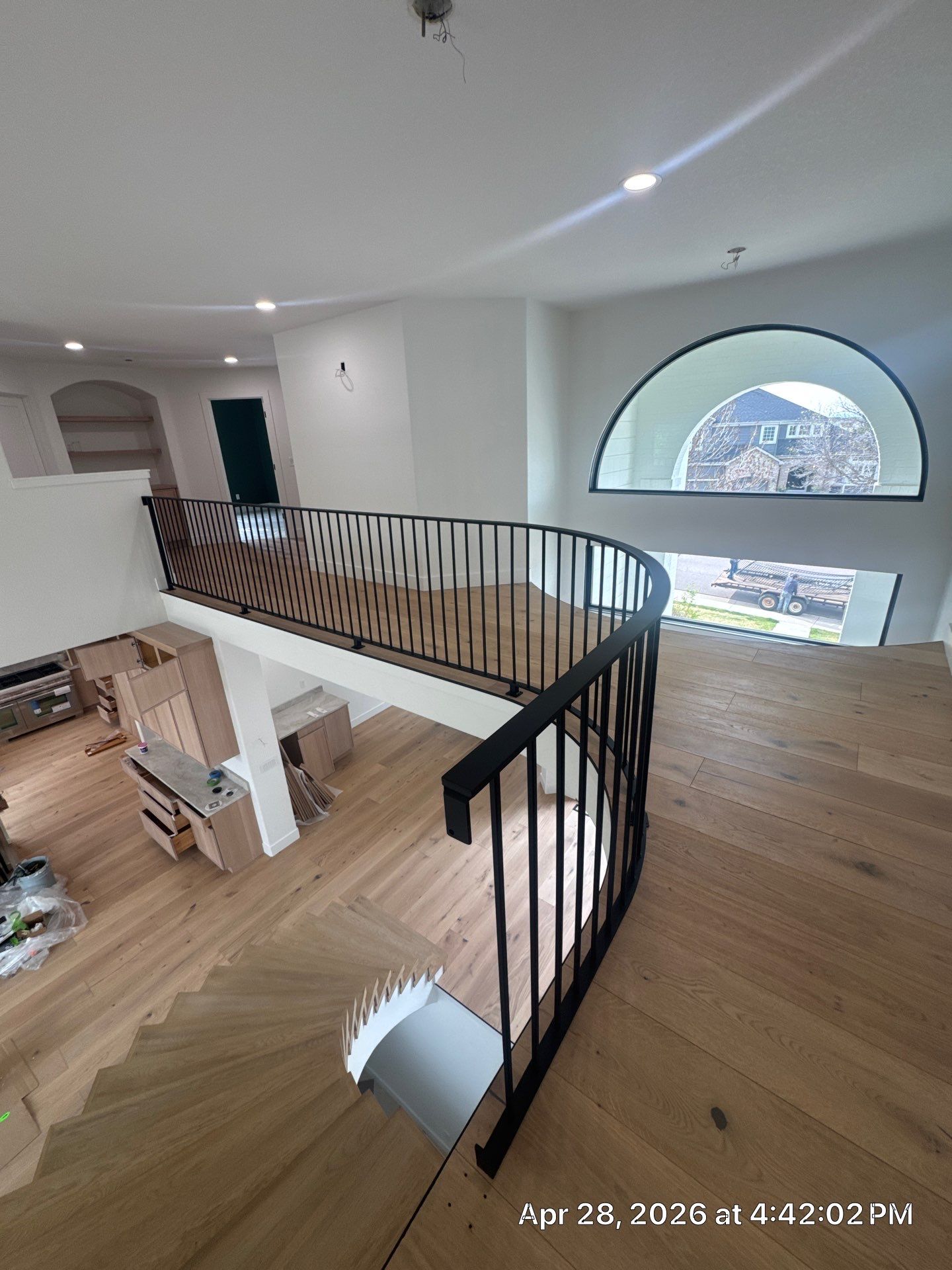 Curved Oak Staircase and Custom Metal Railing Installation in Lone Tree by LP Construction Services