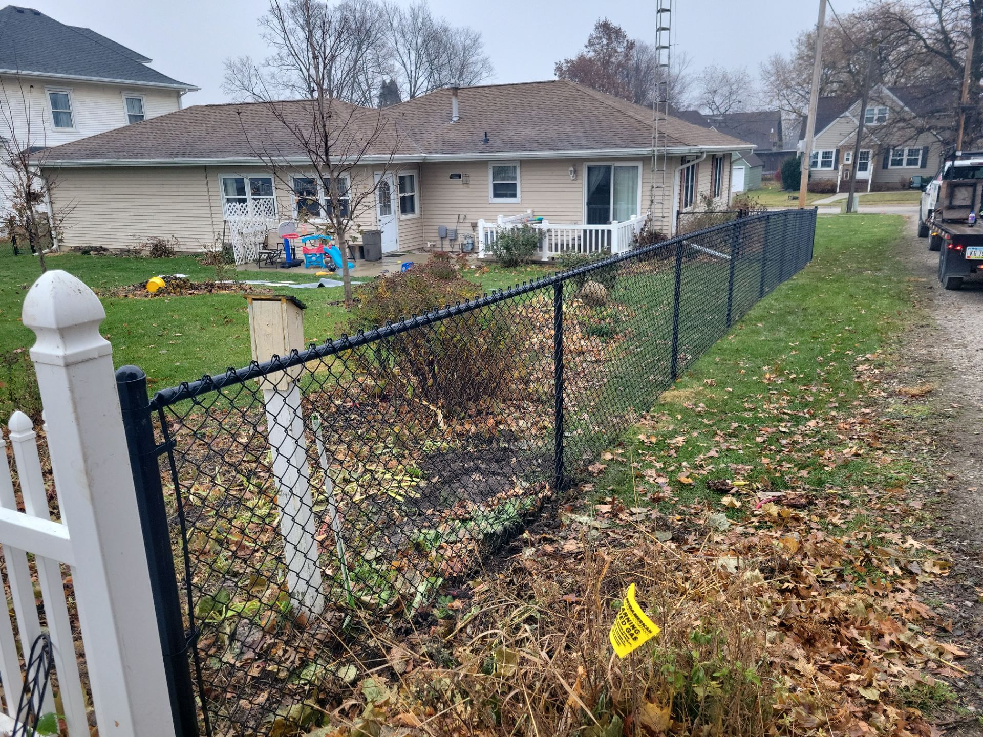Black Vinyl-Coated Chain Link Fence Installation in Aplington by Perfect Picket Fence and Stain