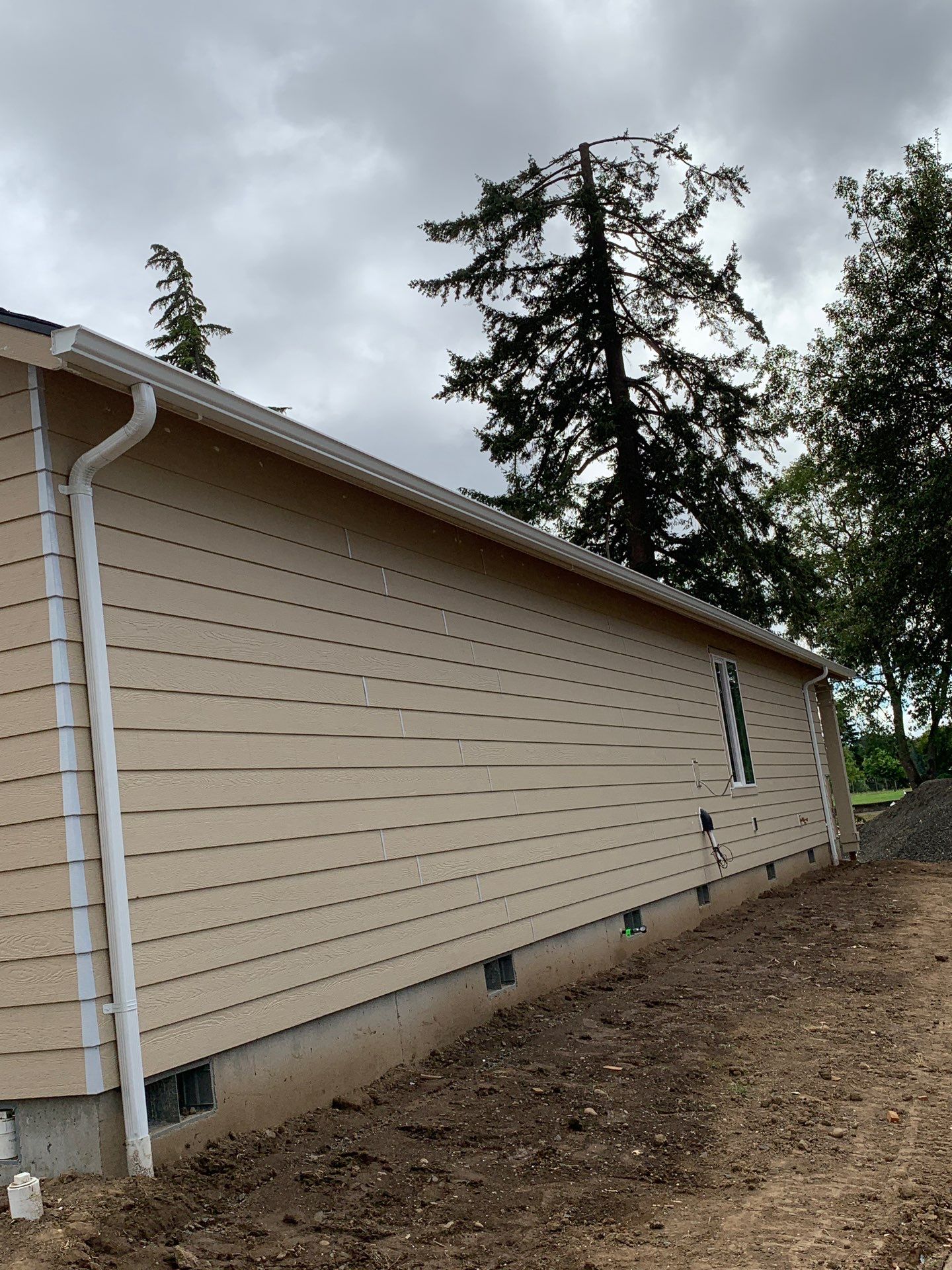 Seamless White Gutter Installation for Eugene New Construction Home by BEST Roofing & Waterproofing