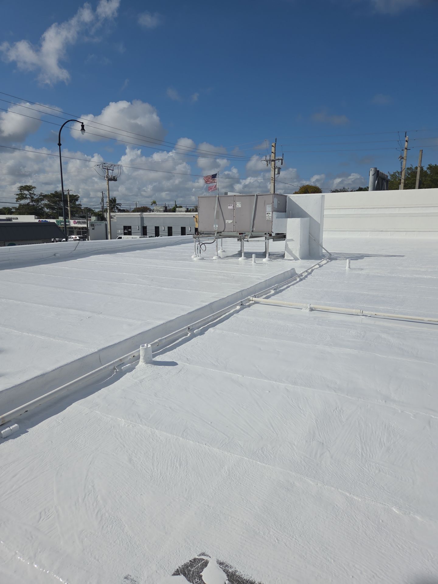 Commercial Flat Roof Restoration Using Silicone Coating in Hallandale Beach by Aastro Roofing