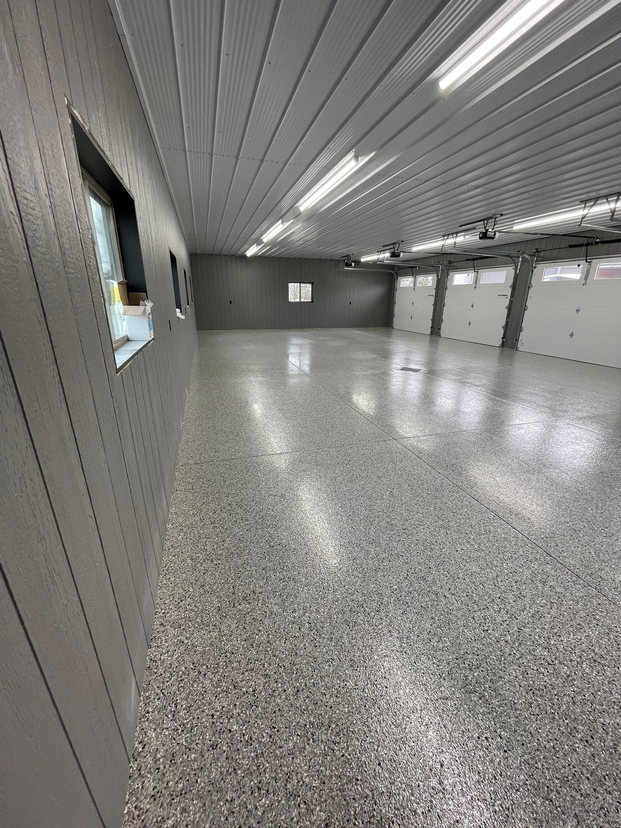 Speckled Epoxy Floor Coating for Large Shop in Rock Valley by Select Painting, Coatings & Garage Cabinets