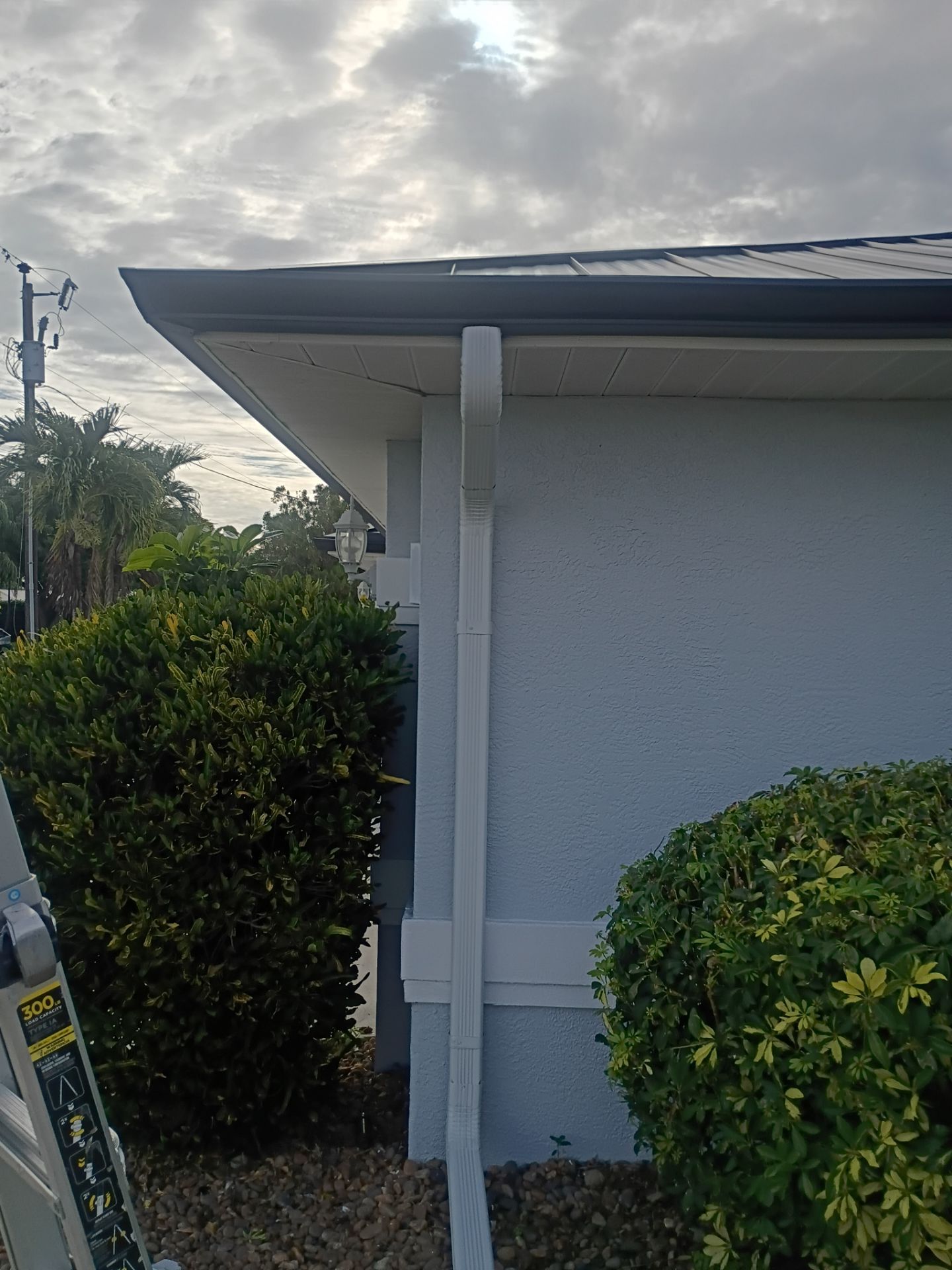 Black Seamless Gutters and White Downspouts in Cape Coral FL by Gutter Professors