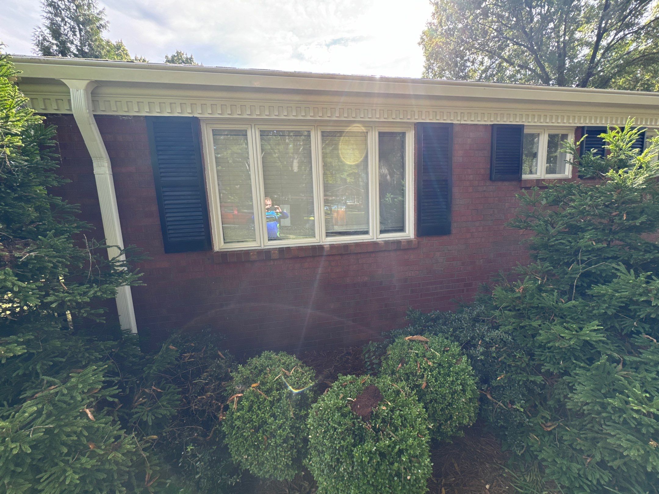 cleaning the brick exterior and windows of a house with a pressure washing service