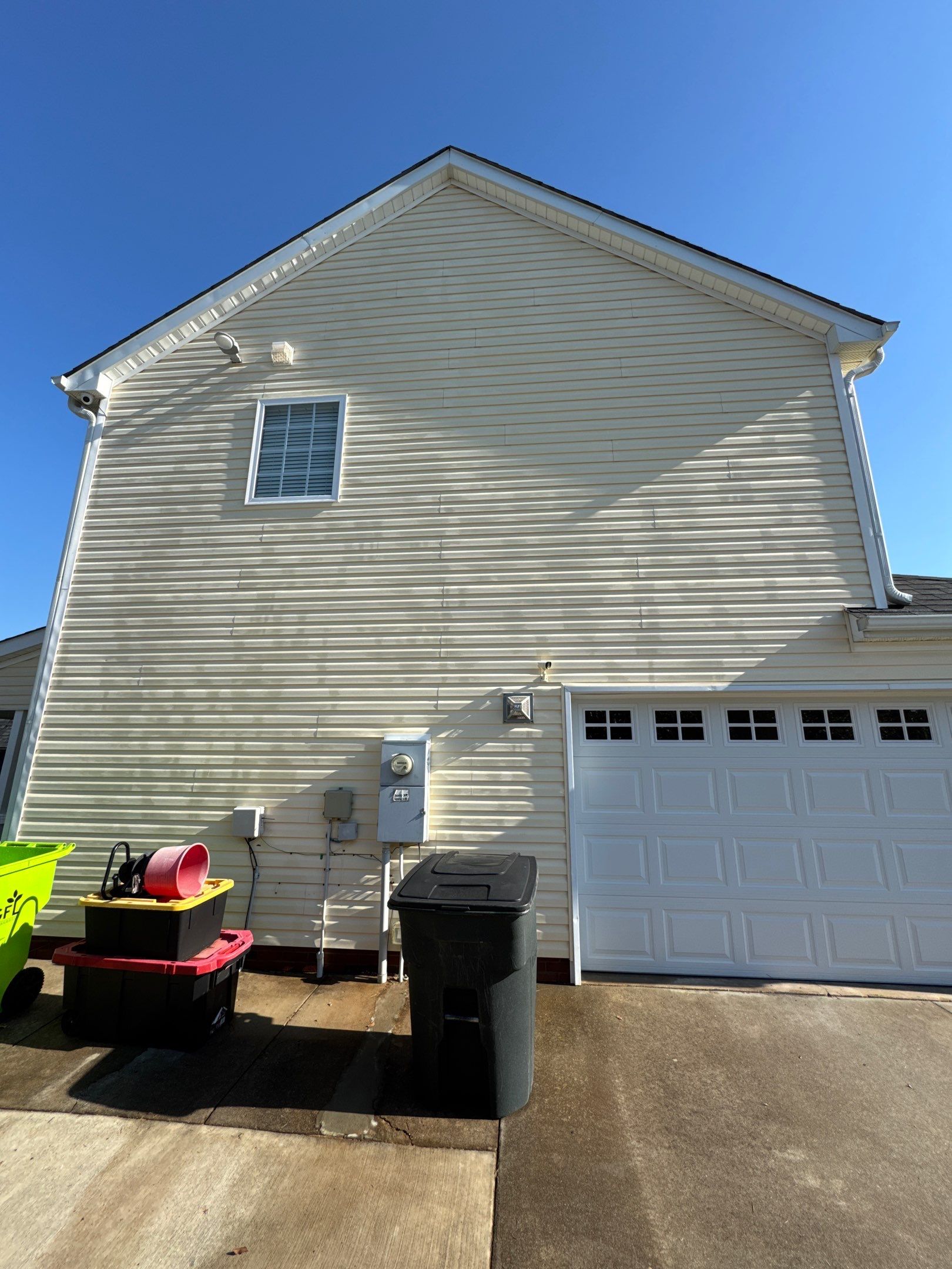 cleaning the exterior vinyl siding and driveway removing dirt and grime for improved appearance and maintenance