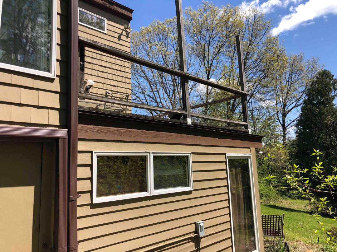 Replacement deck on top of flat roof, Trex Tropical Spiced rum boards and fascia, Trex signature aluminum railings in Black. by DiGiorgi Roofing and Siding Inc
