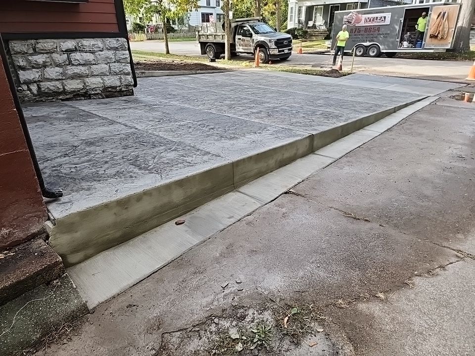 Exterior Renovations- Siding, Stamped Concrete, Porch, and Railings by Ivy Lea Construction