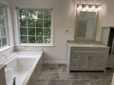 Bathroom Remodel using porcelain tiles , wood make vanetys , mirross , bathroom accessories