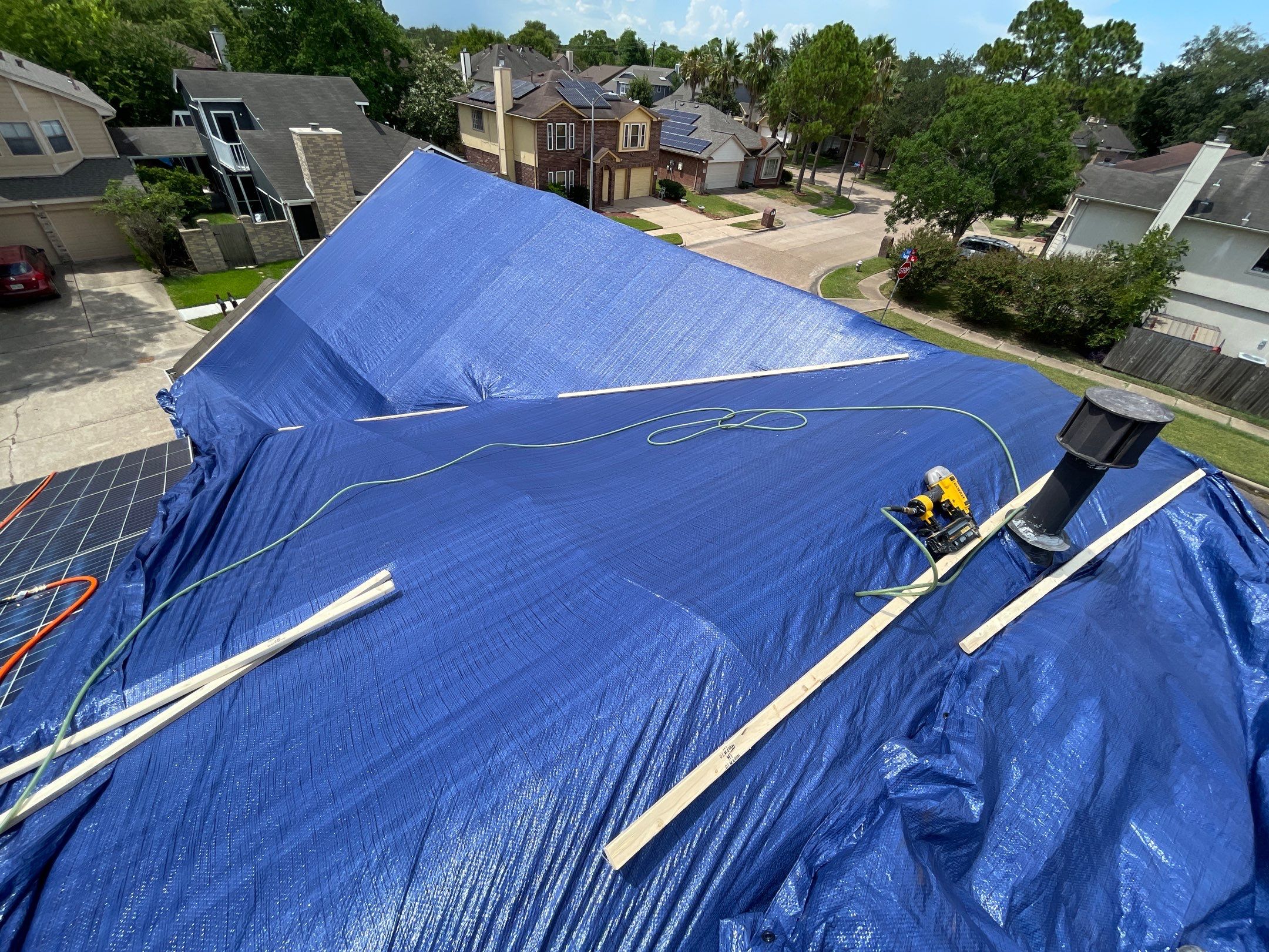 Placement of tarps on the roof. using TARP BLUE by V General Contractors 