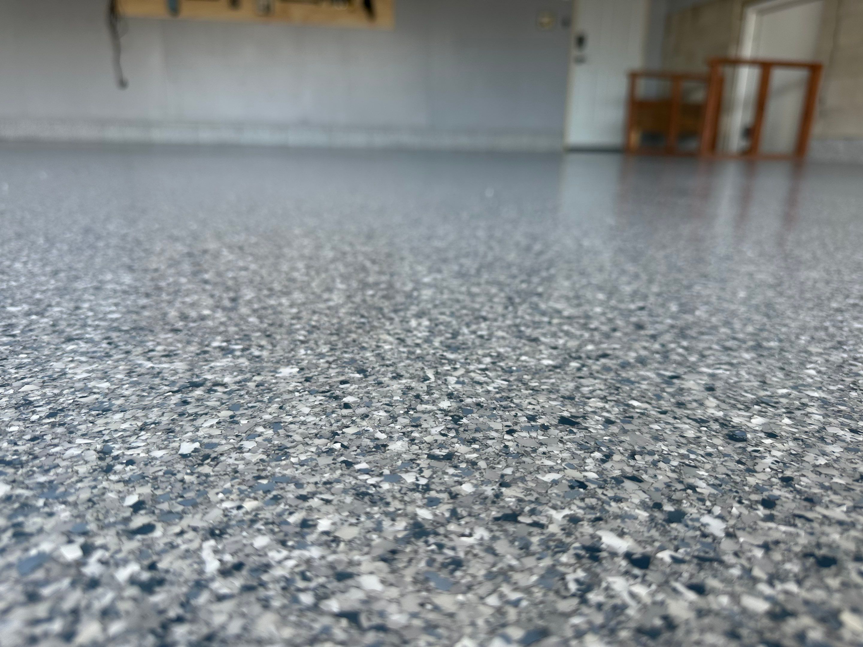 Multi-Colored Speckled Concrete Floor Coating Installation in Sioux Falls by Select Painting, Coatings & Garage Cabinets