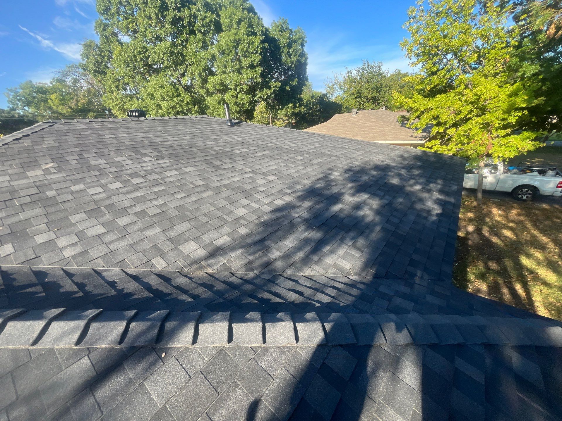 White brick/light gray shutters with IKO Granite Black  by Tejas Roofworks + Restoration