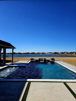 Modern Lakefront Pool with Raised Spa and Dark Interior