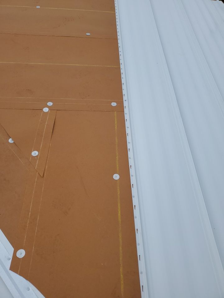 Residential Roofing Installation using 1.5" Nail Strip 24ga Solar White Kynar Coated Standing Seam Metal Panels by Morton Roofing, Inc.