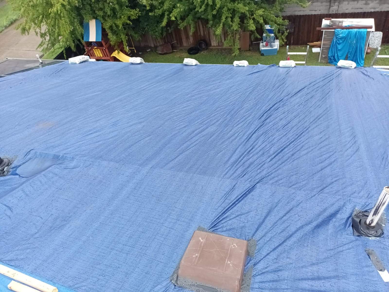 Placement of tarps on the roof. using TARP BLUE by V General Contractors 