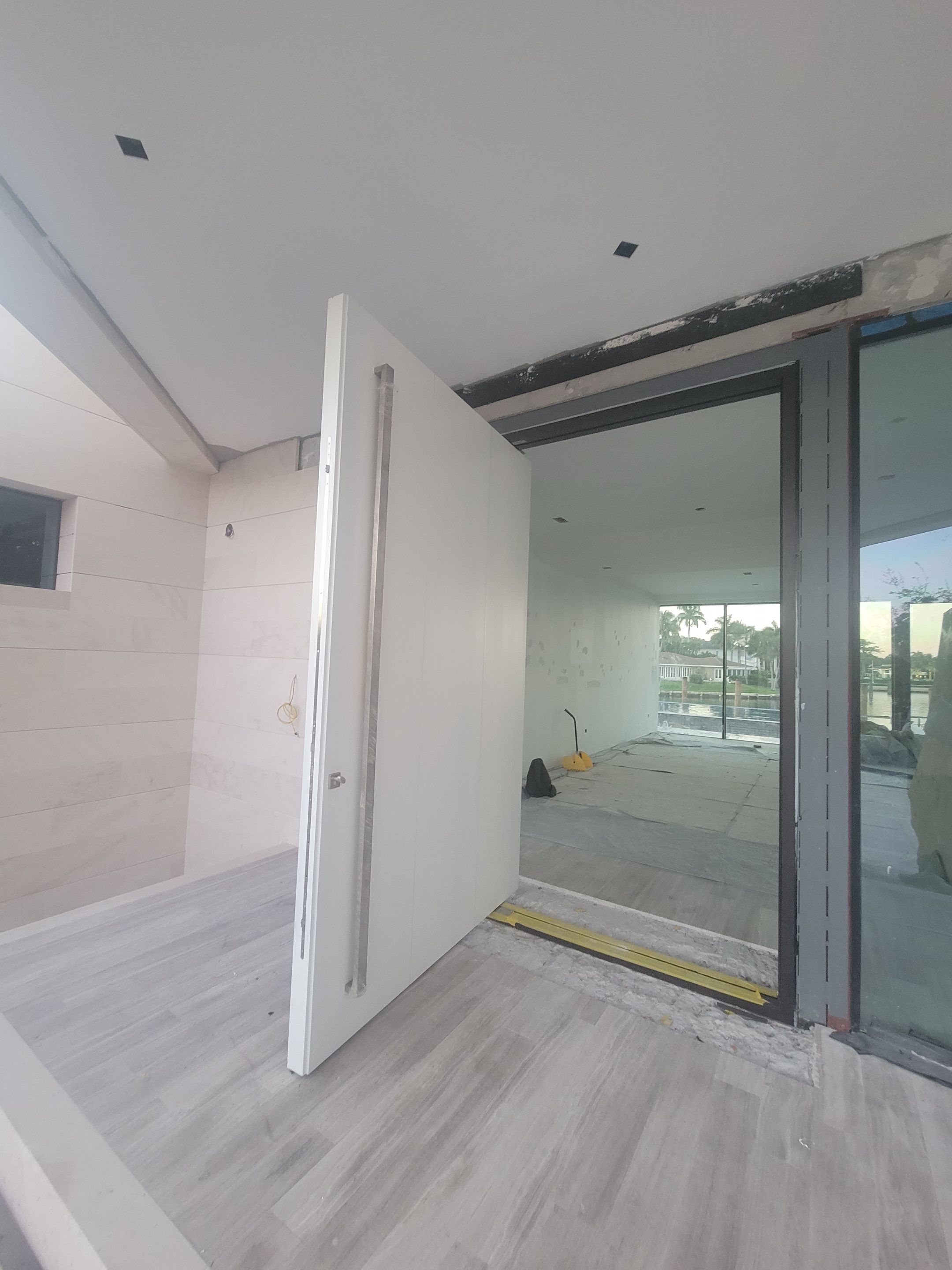 Custom Material Pivot Door installation by Impact Precious Wood Inc.