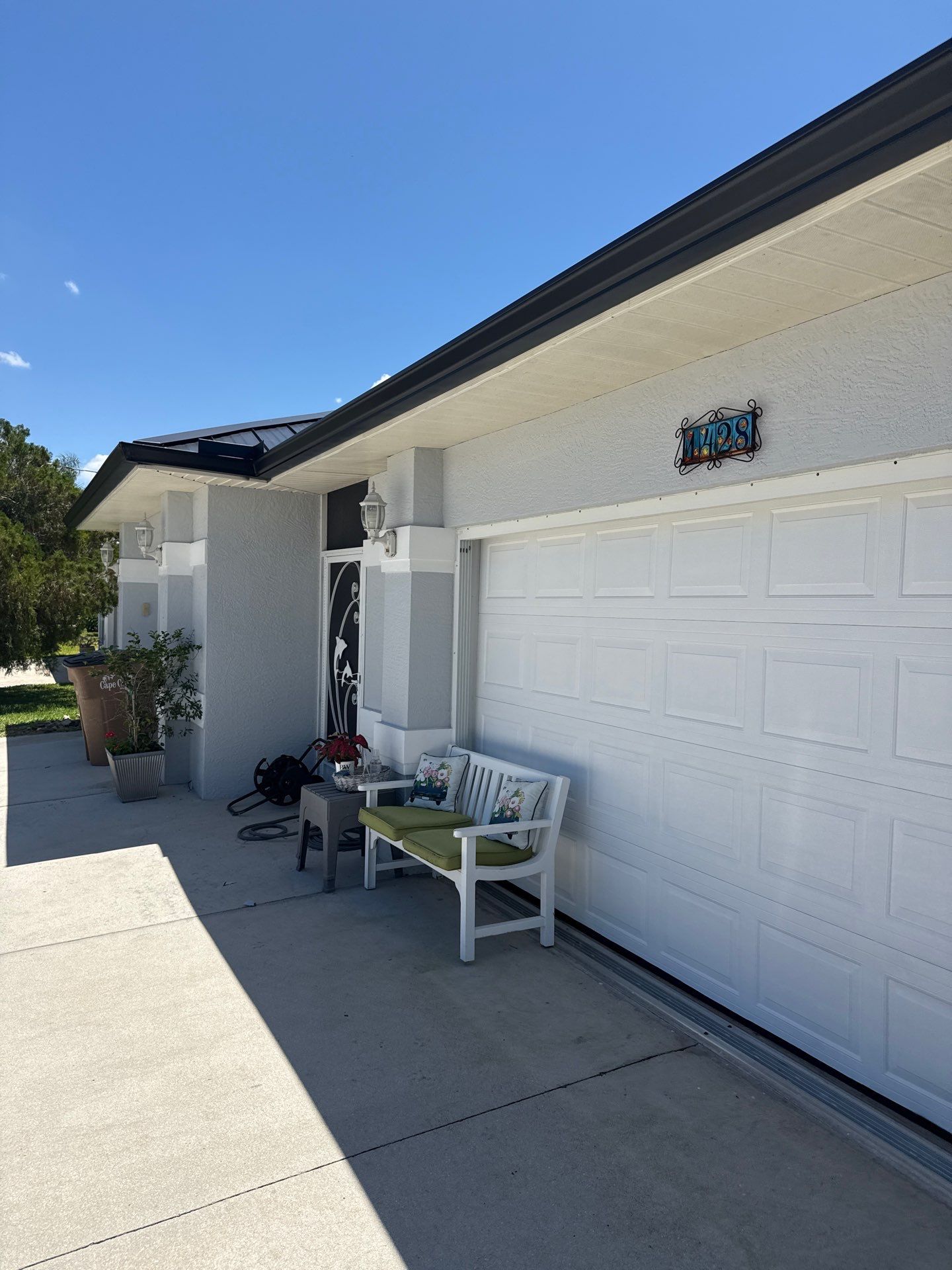 Black Seamless Gutters and White Downspouts in Cape Coral FL by Gutter Professors