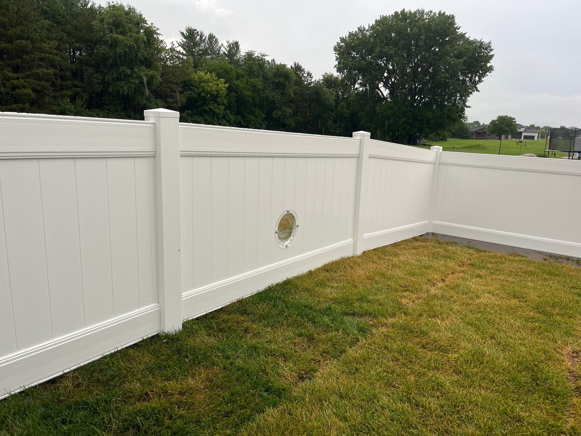 White Vinyl Privacy Fence With Pet Window in Cedar Falls by Perfect Picket Fence and Stain