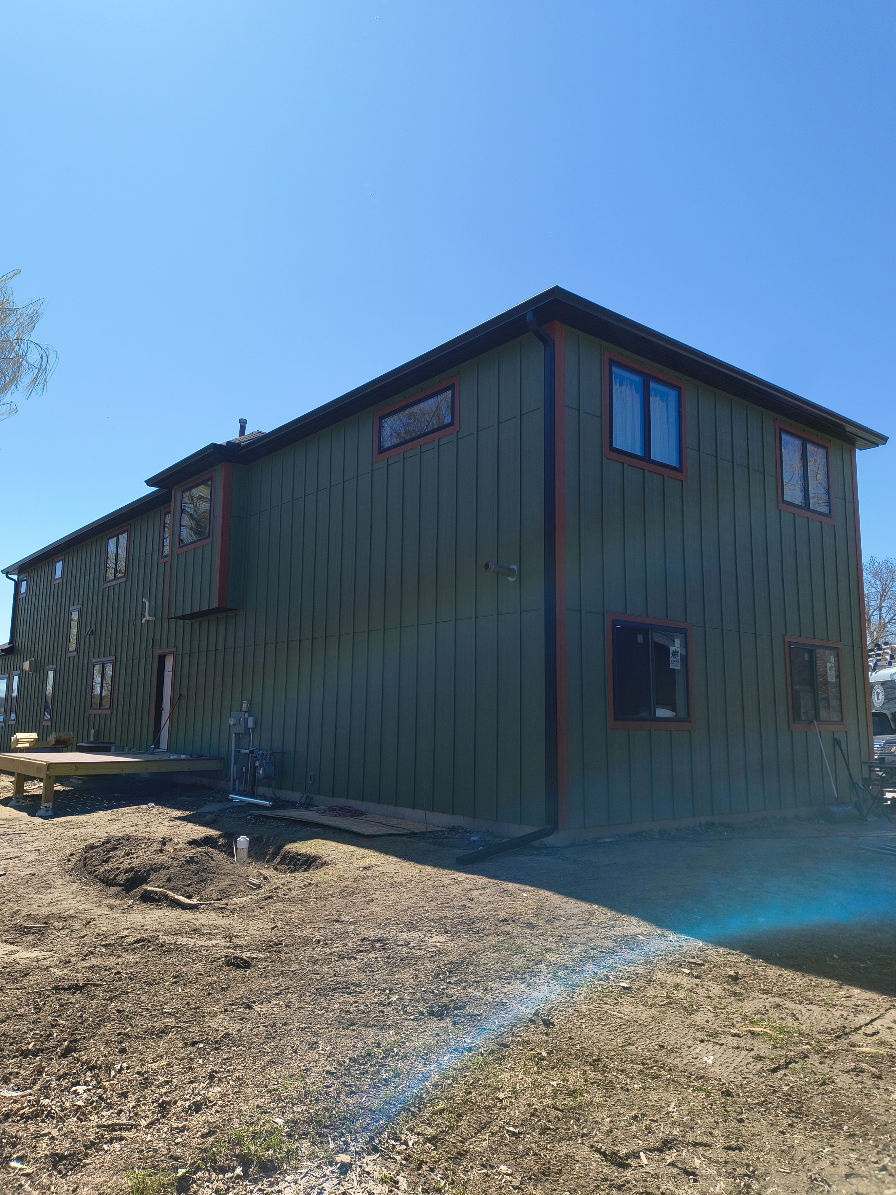 Seamless Gutter Installation in Annandale MN | 6” Black Gutters on Green Home by Next Level Seamless Gutters / Exteriors Inc.