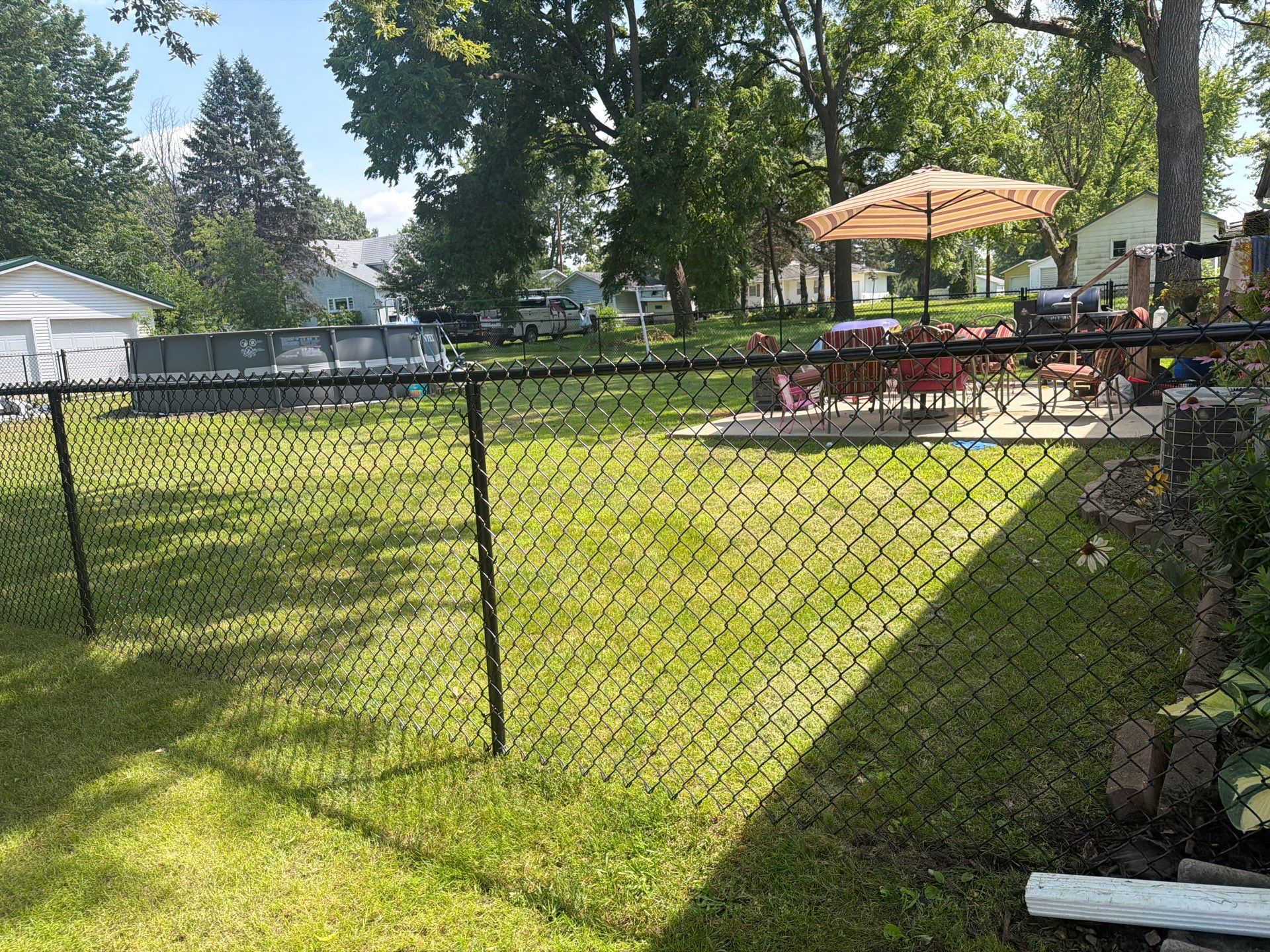 Black Chain Link Backyard Fence Installation in Tripoli, IA by Perfect Picket Fence and Stain