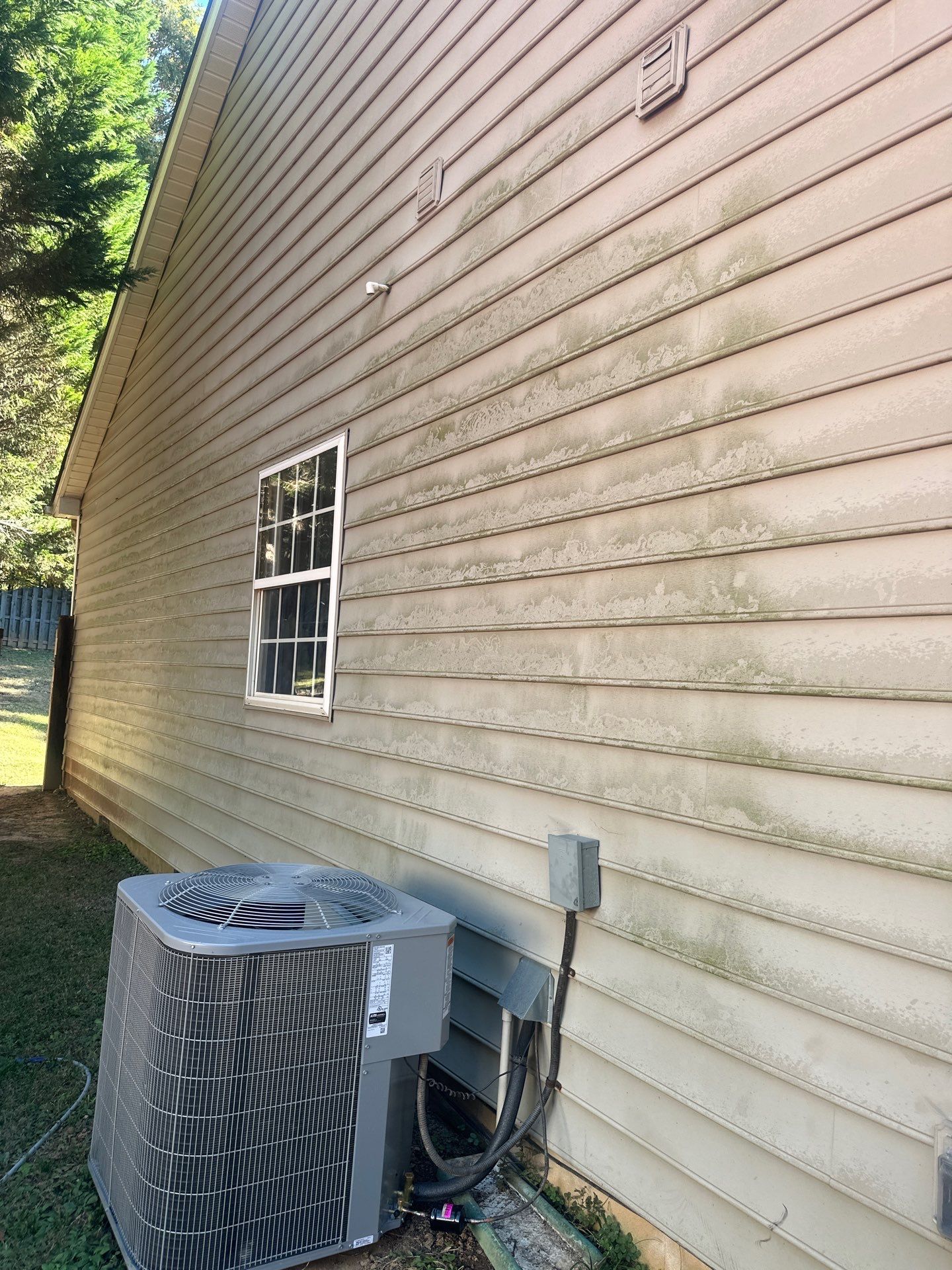 the photo shows cleaning of dirty siding using pressure washing techniques to remove grime and improve appearance