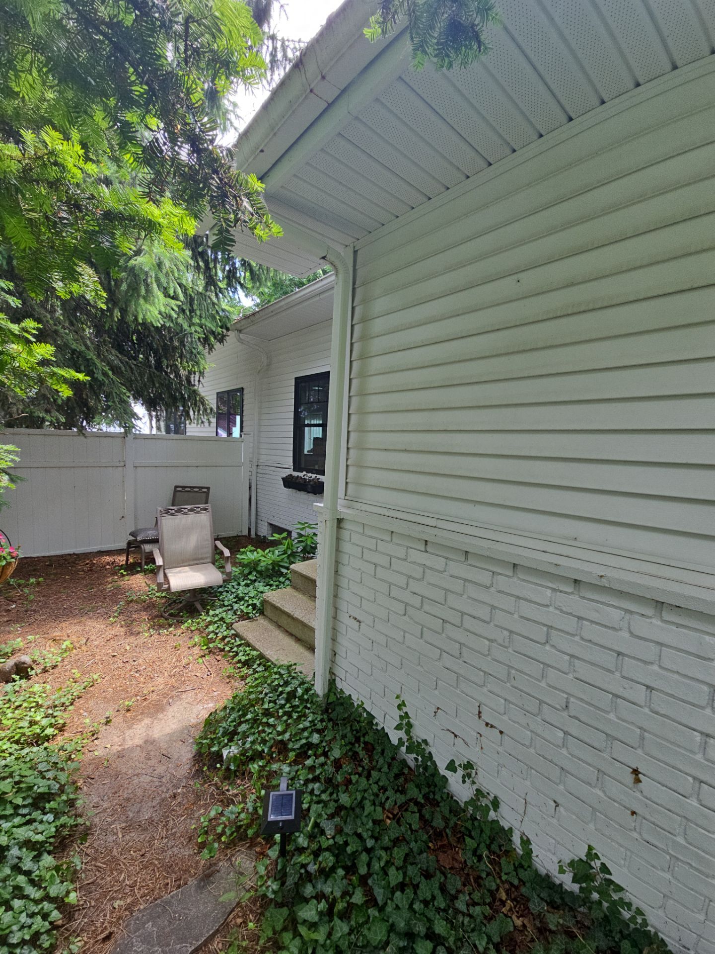 Black Gutter and Gutter Helmet Installation for Suttons Bay Home by Rainbow Seamless Systems