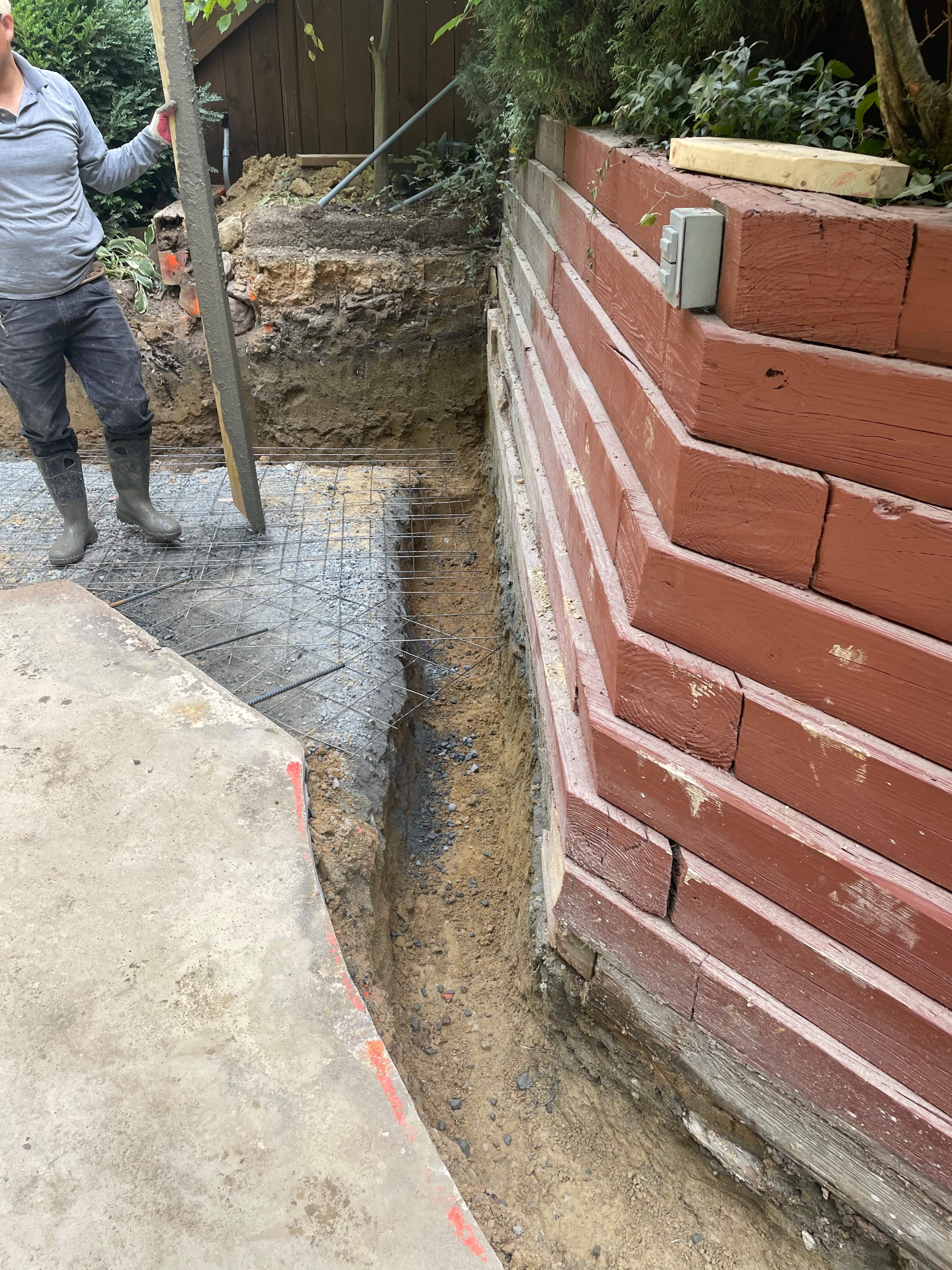 Pool Surround remodel with retaining walls, new waterfall and water slide by Fairfax Contractors, LLC